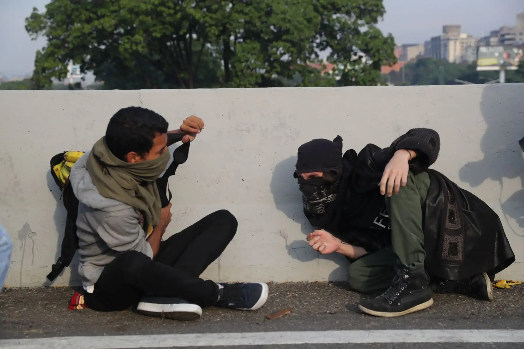 Simpatizantes del presidente interno Juan Guaidó se protegen de las bombas lacrimógenas que las fuerzas de seguridad leales al Gobierno de Nicolás Maduro lanzan en la base militar de La Carlota, donde se encuentra el presidente interino Juan Guaidó y un grupo de militares que le apoyan.Foto: EFE Simpatizantes del presidente interno Juan Guaidó se protegen de las bombas lacrimógenas que las fuerzas de seguridad leales al Gobierno de Nicolás Maduro lanzan en la base militar de La Carlota, donde se encuentra el presidente interino Juan Guaidó y un grupo de militares que le apoyan.Foto: EFE