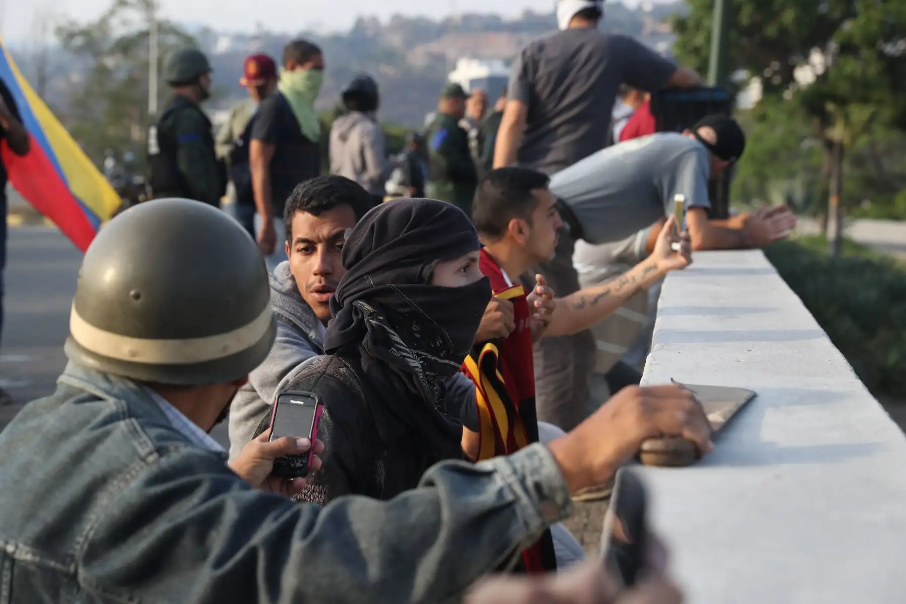 Simpatizantes del presidente interno Juan Guaidó se protegen de las bombas lacrimógenas que las fuerzas de seguridad leales al Gobierno de Nicolás Maduro lanzan en la base militar de La Carlota, donde se encuentra el presidente interino Juan Guaidó y un grupo de militares que le apoyan.Foto: EFE Simpatizantes del presidente interno Juan Guaidó se protegen de las bombas lacrimógenas que las fuerzas de seguridad leales al Gobierno de Nicolás Maduro lanzan en la base militar de La Carlota, donde se encuentra el presidente interino Juan Guaidó y un grupo de militares que le apoyan.Foto: EFE