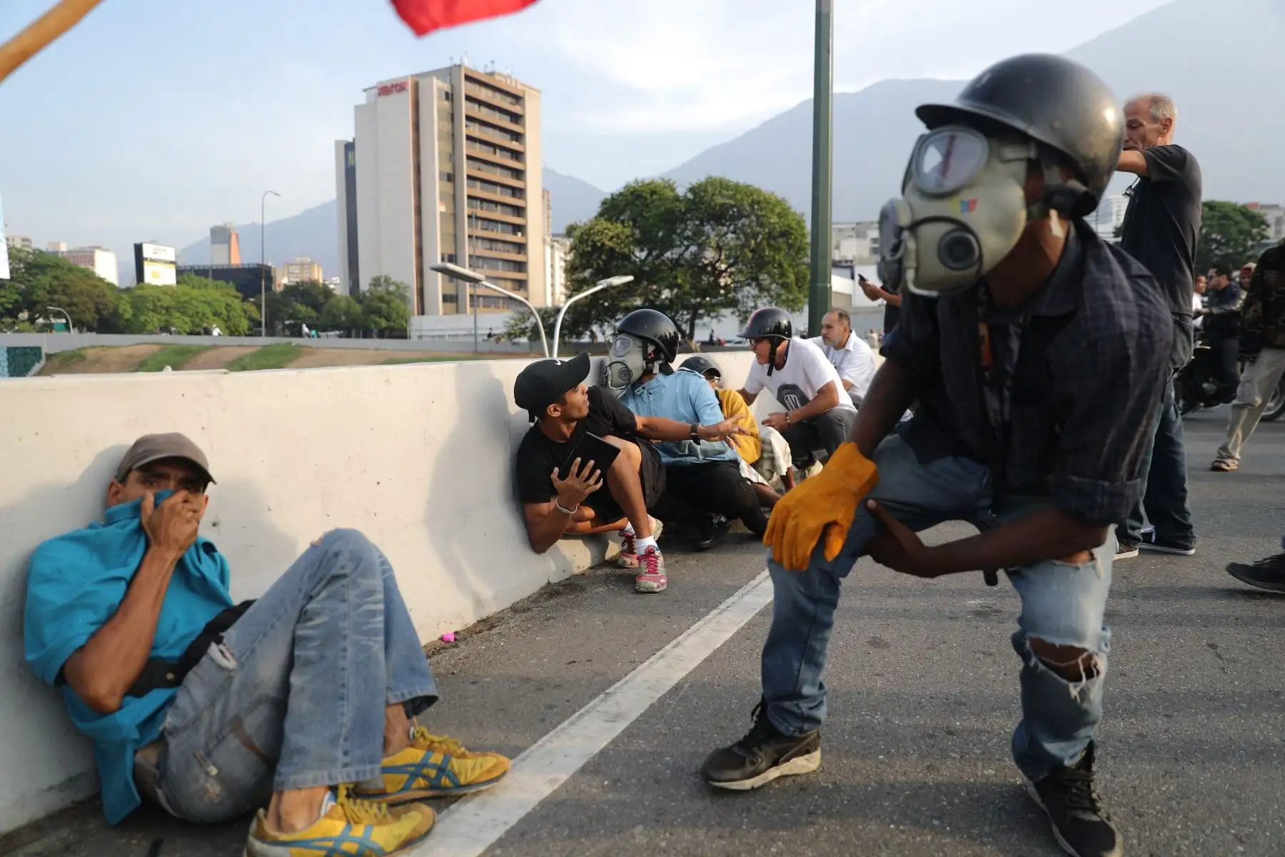 Simpatizantes del presidente interno Juan Guaidó se protegen de las bombas lacrimógenas que las fuerzas de seguridad leales al Gobierno de Nicolás Maduro lanzan en la base militar de La Carlota, donde se encuentra el presidente interino Juan Guaidó y un grupo de militares que le apoyan.Foto: EFE Simpatizantes del presidente interno Juan Guaidó se protegen de las bombas lacrimógenas que las fuerzas de seguridad leales al Gobierno de Nicolás Maduro lanzan en la base militar de La Carlota, donde se encuentra el presidente interino Juan Guaidó y un grupo de militares que le apoyan.Foto: EFE