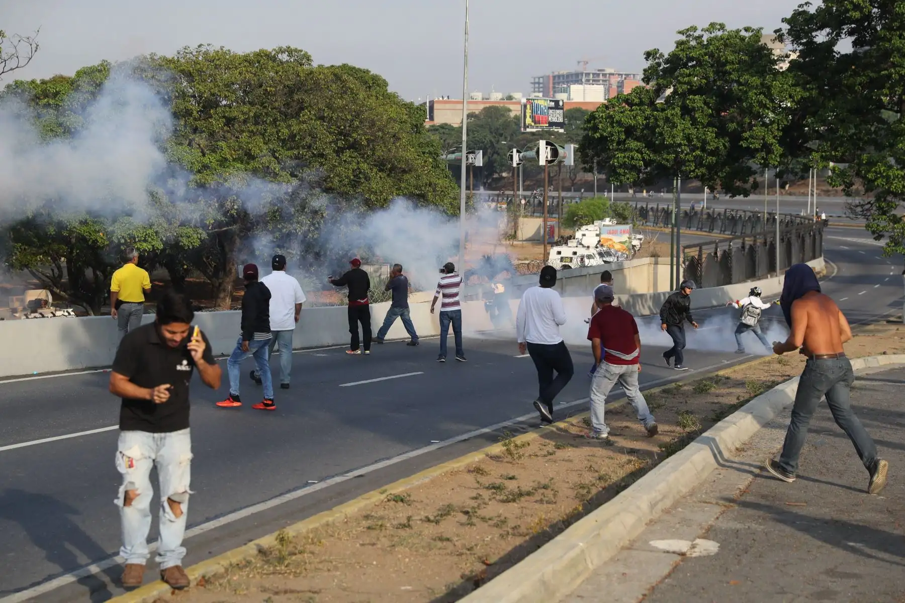 Simpatizantes del presidente interno Juan Guaidó se protegen de las bombas lacrimógenas que las fuerzas de seguridad leales al Gobierno de Nicolás Maduro lanzan en la base militar de La Carlota, donde se encuentra el presidente interino Juan Guaidó y un grupo de militares que le apoyan.Foto: EFE Simpatizantes del presidente interno Juan Guaidó se protegen de las bombas lacrimógenas que las fuerzas de seguridad leales al Gobierno de Nicolás Maduro lanzan en la base militar de La Carlota, donde se encuentra el presidente interino Juan Guaidó y un grupo de militares que le apoyan.Foto: EFE