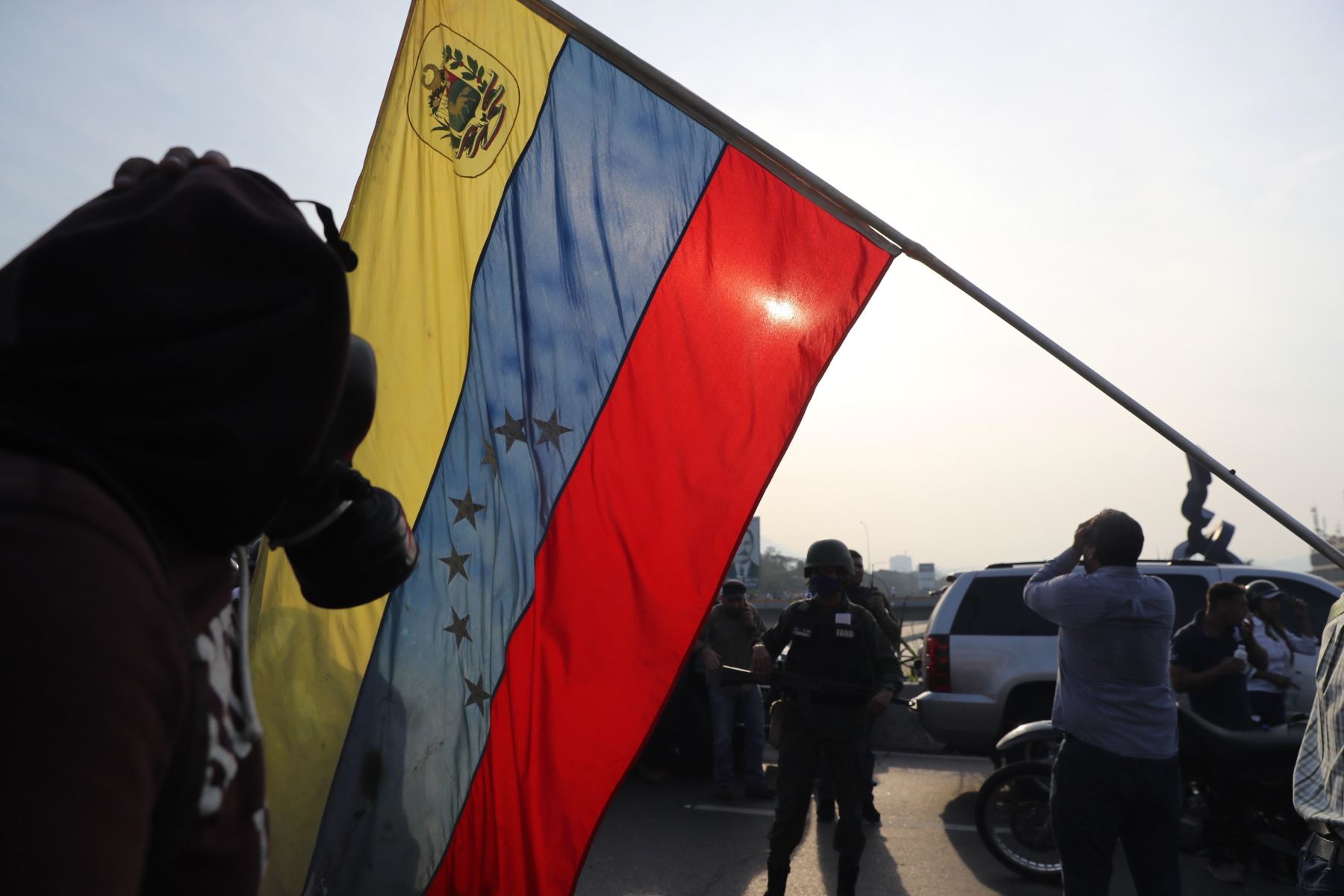 Simpatizantes del presidente interino Juan Guaidó ondean banderas este martes en la base militar de La Carlota, donde se encuentra Guaidó y un grupo de militares que le apoyan. Foto: EFE