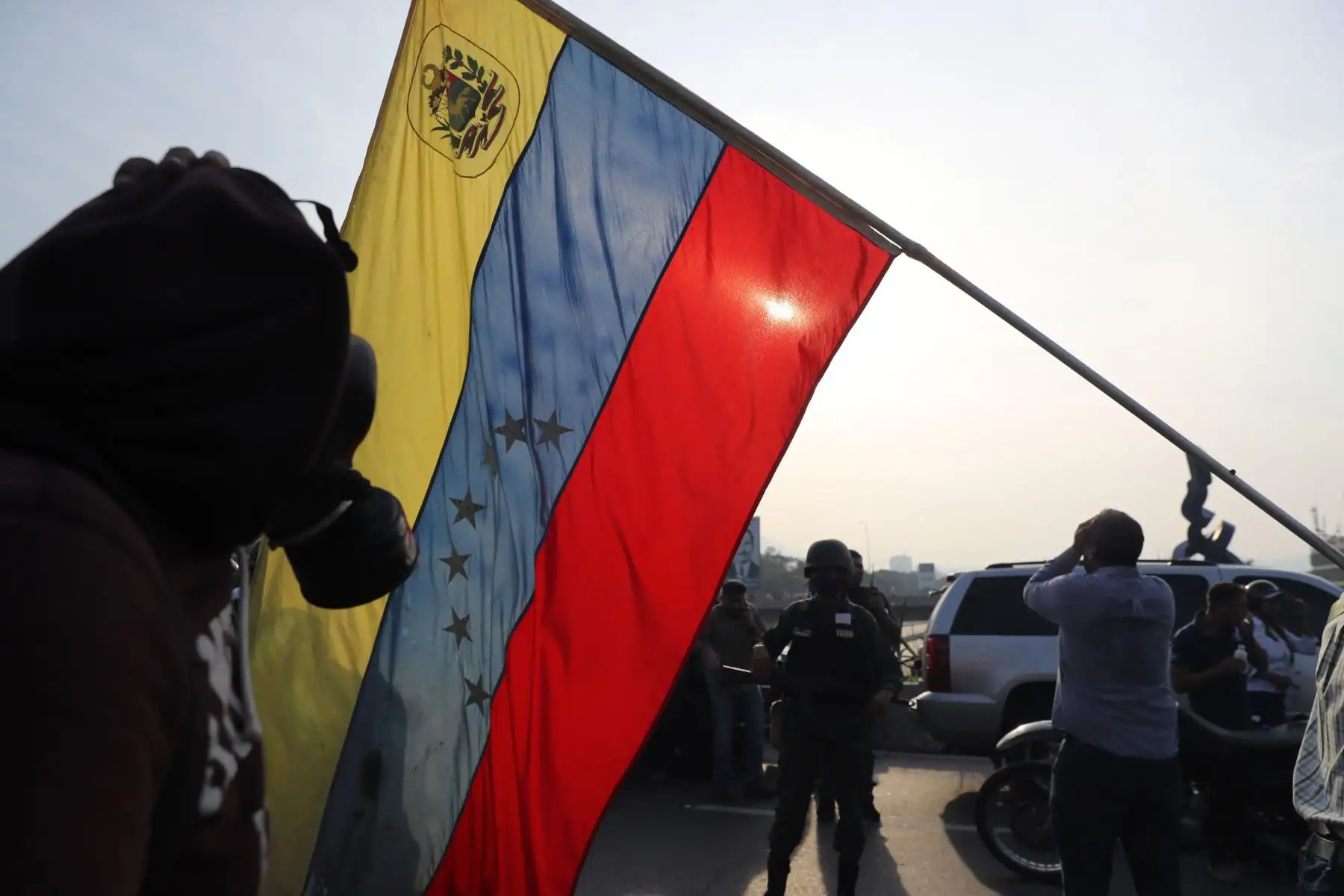 Simpatizantes del presidente interino Juan Guaidó ondean banderas este martes en la base militar de La Carlota, donde se encuentra Guaidó y un grupo de militares que le apoyan. Foto: EFE Simpatizantes del presidente interino Juan Guaidó ondean banderas este martes en la base militar de La Carlota, donde se encuentra Guaidó y un grupo de militares que le apoyan. Foto: EFE
