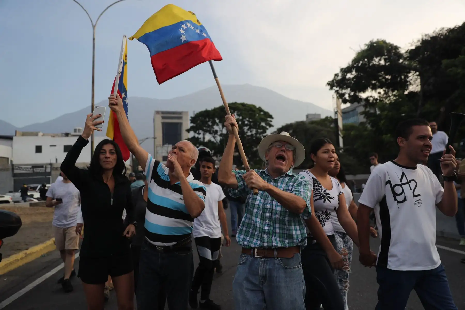 Simpatizantes del presidente interino Juan Guaidó ondean banderas este martes en la base militar de La Carlota, donde se encuentra Guaidó y un grupo de militares que le apoyan. Foto: EFE Simpatizantes del presidente interino Juan Guaidó ondean banderas este martes en la base militar de La Carlota, donde se encuentra Guaidó y un grupo de militares que le apoyan. Foto: EFE
