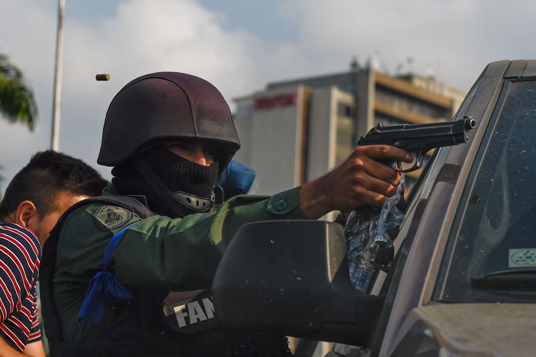 Un miembro de la Guardia Nacional Bolivariana que se unió al presidente interino, Juan Guaidó, apunta con su arma mientras repelen a las fuerzas leales al presidente Nicolás Maduro, en la base militar de La Carlota en Caracas. Foto: AFP