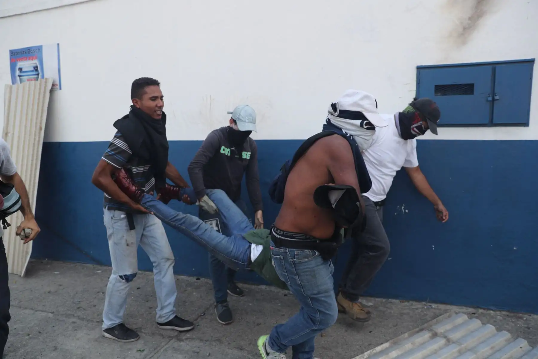 Simpatizantes del presidente interino Juan Guaidó, ayudan a un herido durante una manifestación en contra de Nicolás Maduro. Foto: EFE