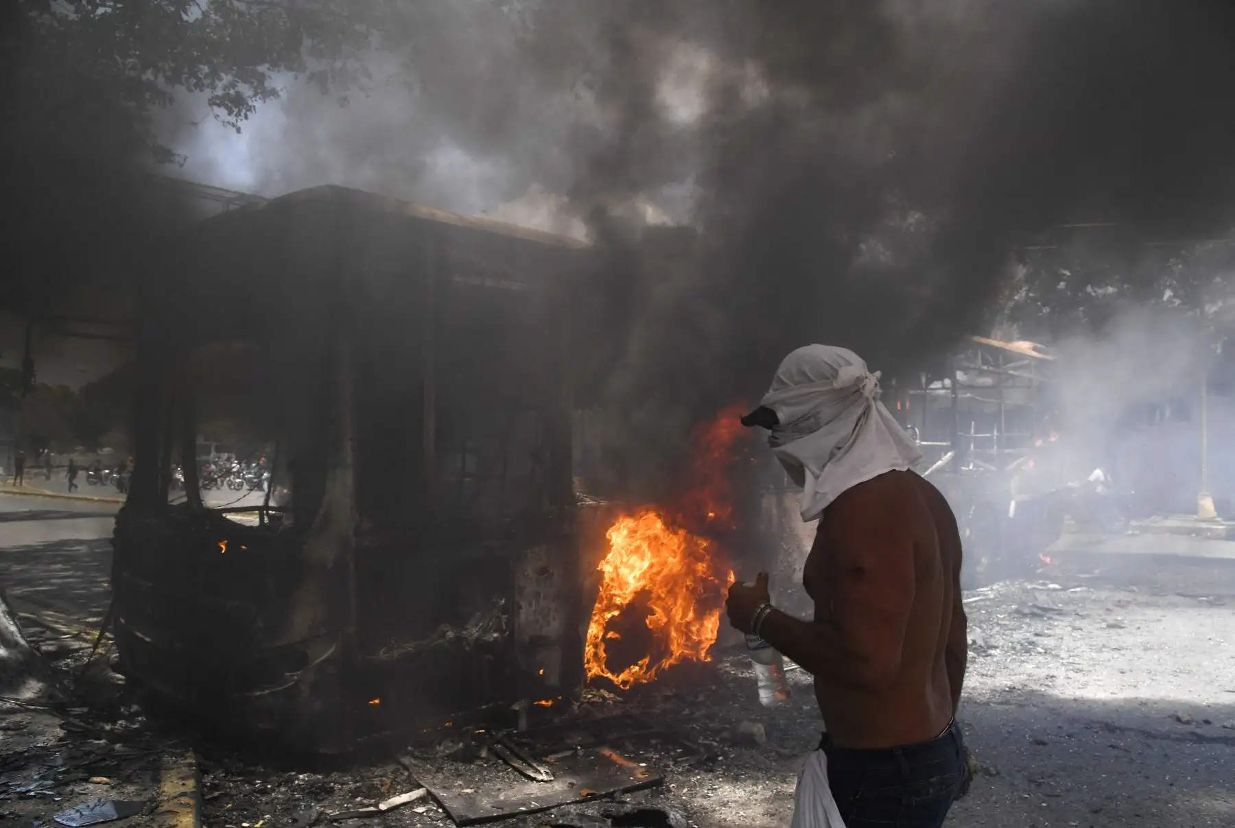 Un manifestante de la oposición es visto junto a un autobús del gobierno incendiado durante los enfrentamientos con soldados leales a Maduro después de que las tropas se unieran al presidente interino Juan Guaidó.
Foto: AFP