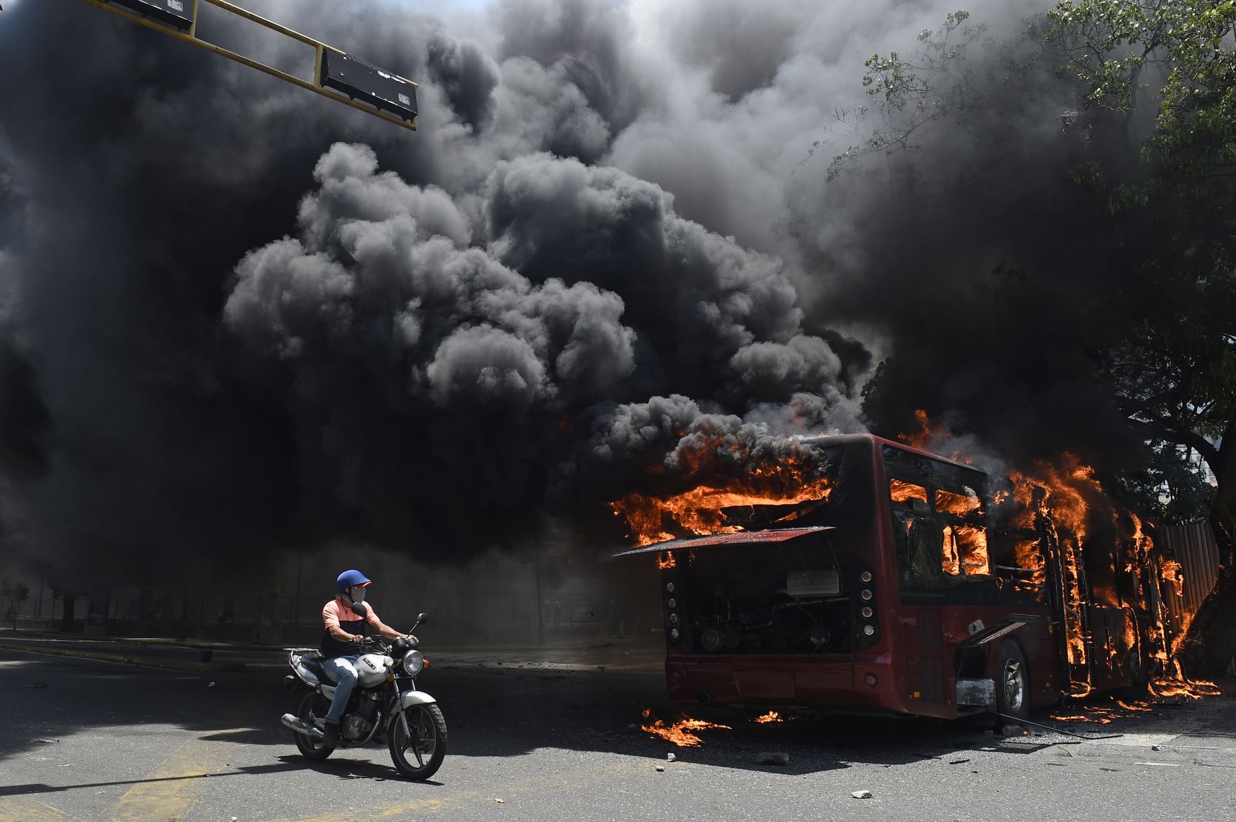 Un manifestante de la oposición pasa junto a un autobús del gobierno incendiado durante los enfrentamientos con soldados leales aMaduro, luego de que las tropas se unieran al presidente interino Juan Guaido.
Foto: AFP