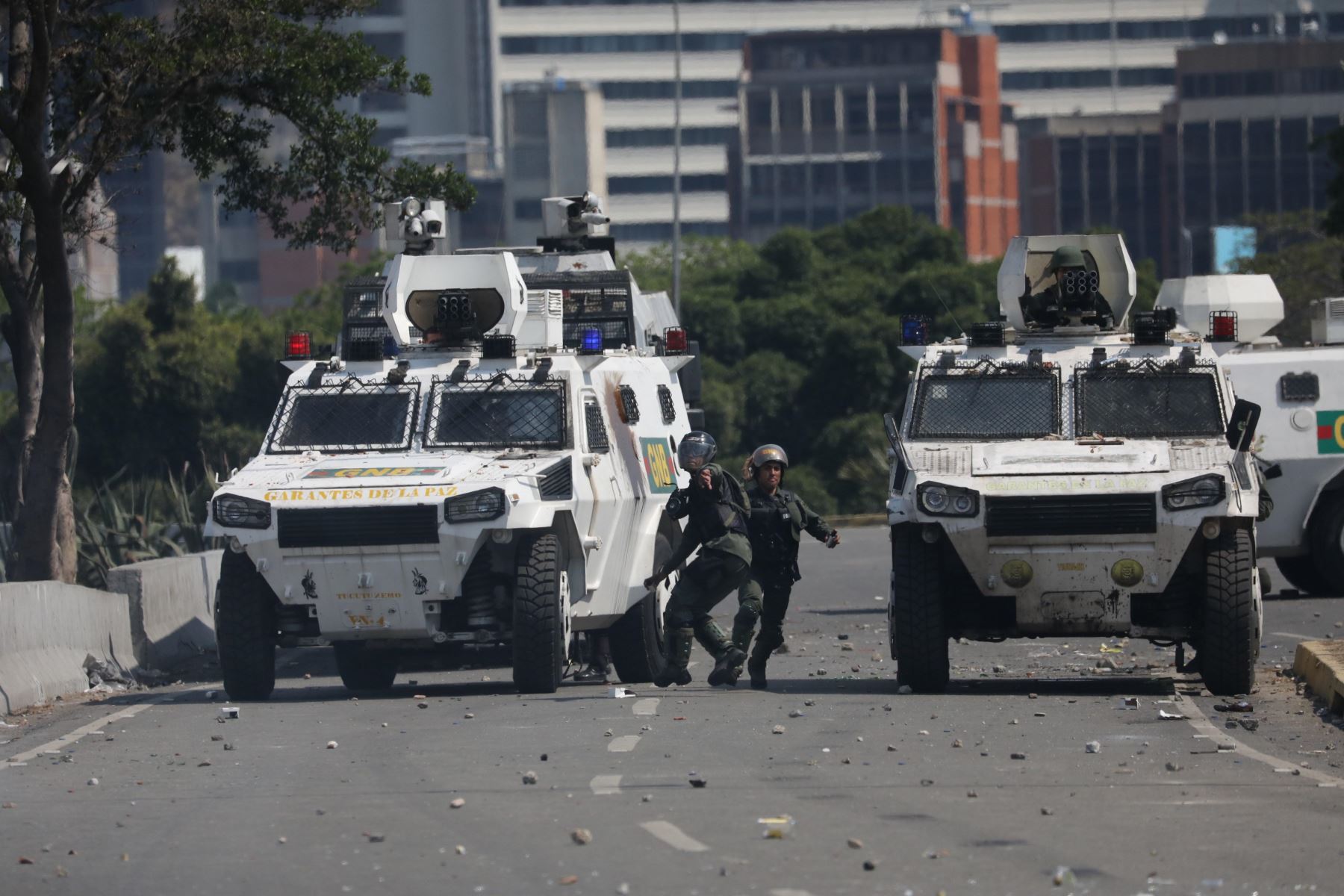 Un manifestante de la oposición pasa junto a un autobús del gobierno incendiado durante los enfrentamientos con soldados leales a Maduro, luego de que las tropas se unieran al presidente interino íJuan Guaido. Foto:AFP