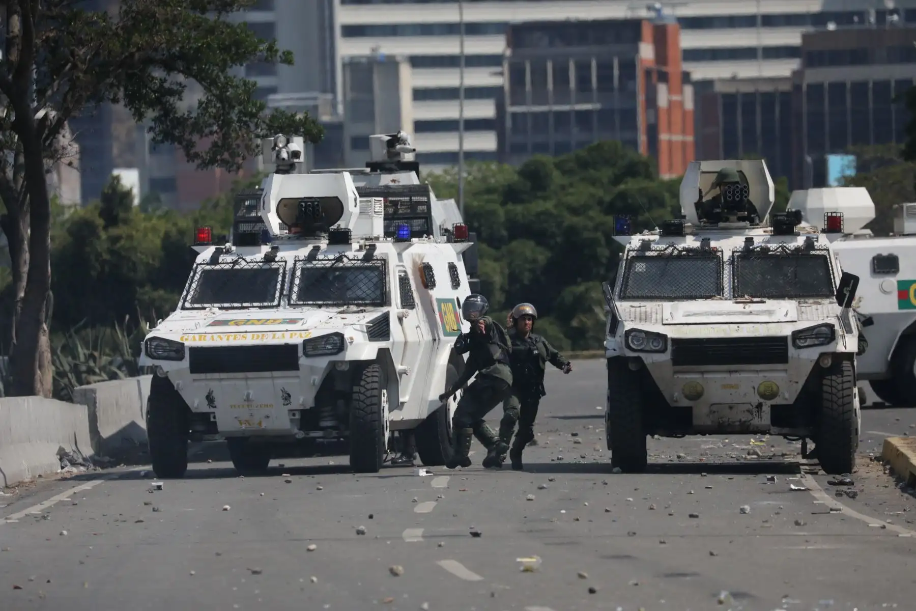 Un manifestante de la oposición pasa junto a un autobús del gobierno incendiado durante los enfrentamientos con soldados leales a Maduro, luego de que las tropas se unieran al presidente interino íJuan Guaido. Foto:AFP