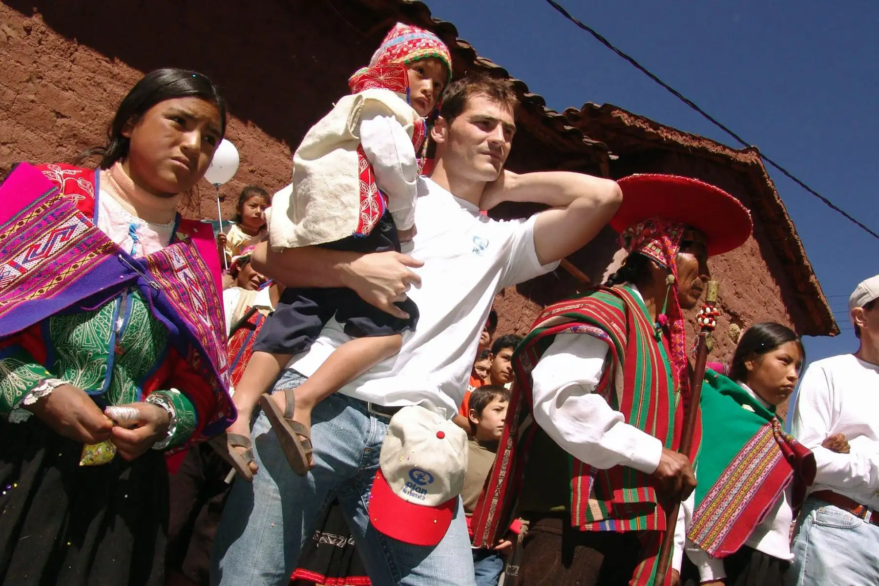 El ​​portero Iker Casillas, lleva a un niño de la comunidad de Patabamba, en Cusco, Perú. Foto: AFP