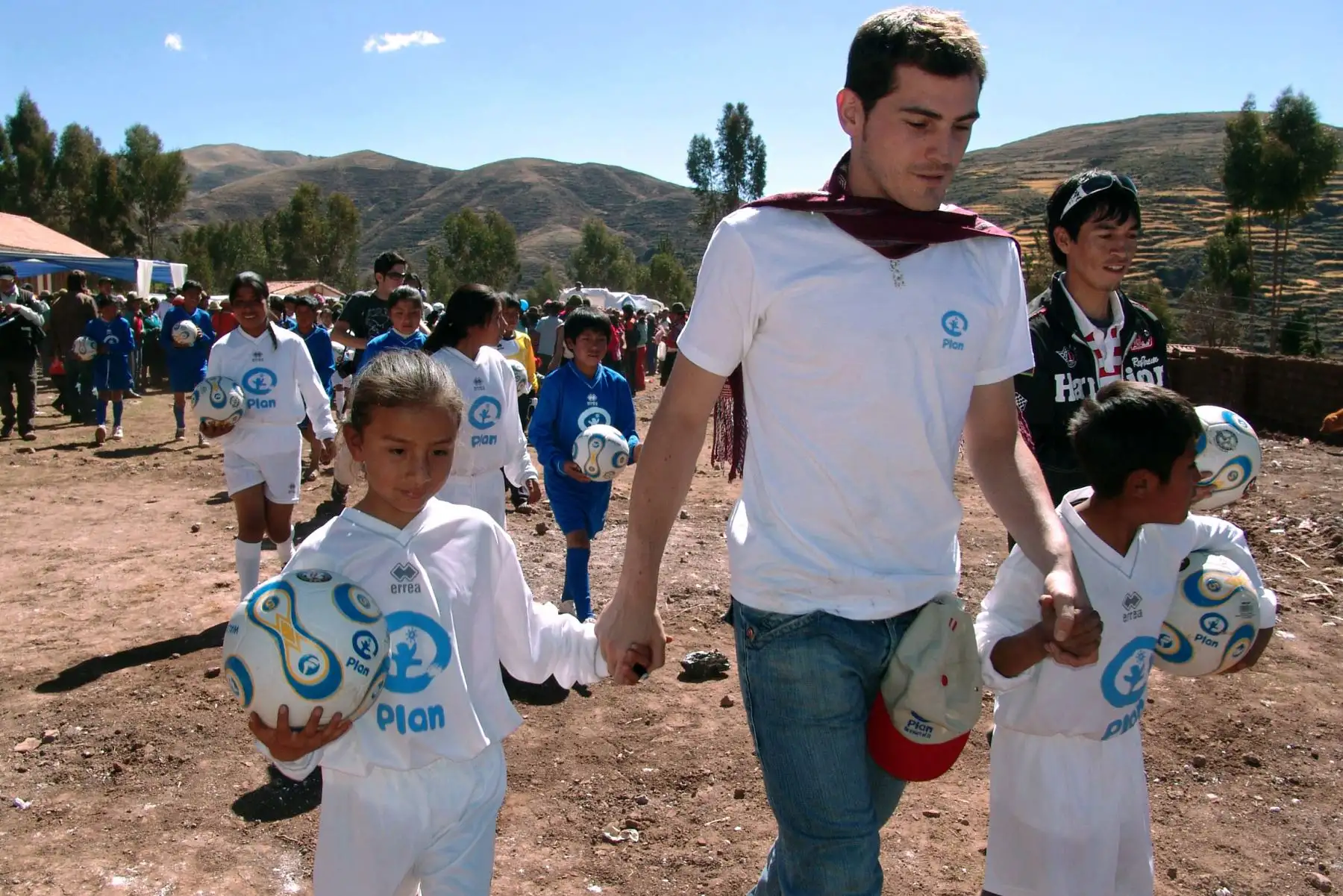 El portero Iker Casillas, camina con niños en la comunidad de Patabamba, en Cusco, Perú, el 5 de julio de 2008. Foto: AFP