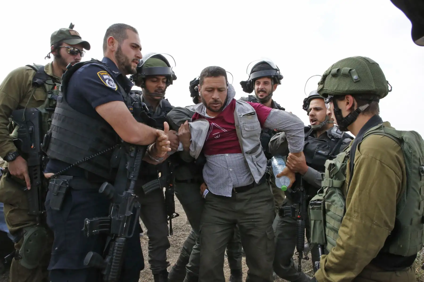 Fuerzas israelíes inmovilizan a activistas mientras que militantes extranjeros, israelíes y palestinos intentan despejar un camino que conduce a las aldeas palestinas, cerca de la ciudad de Yatta en la Cisjordania. Foto: AFP