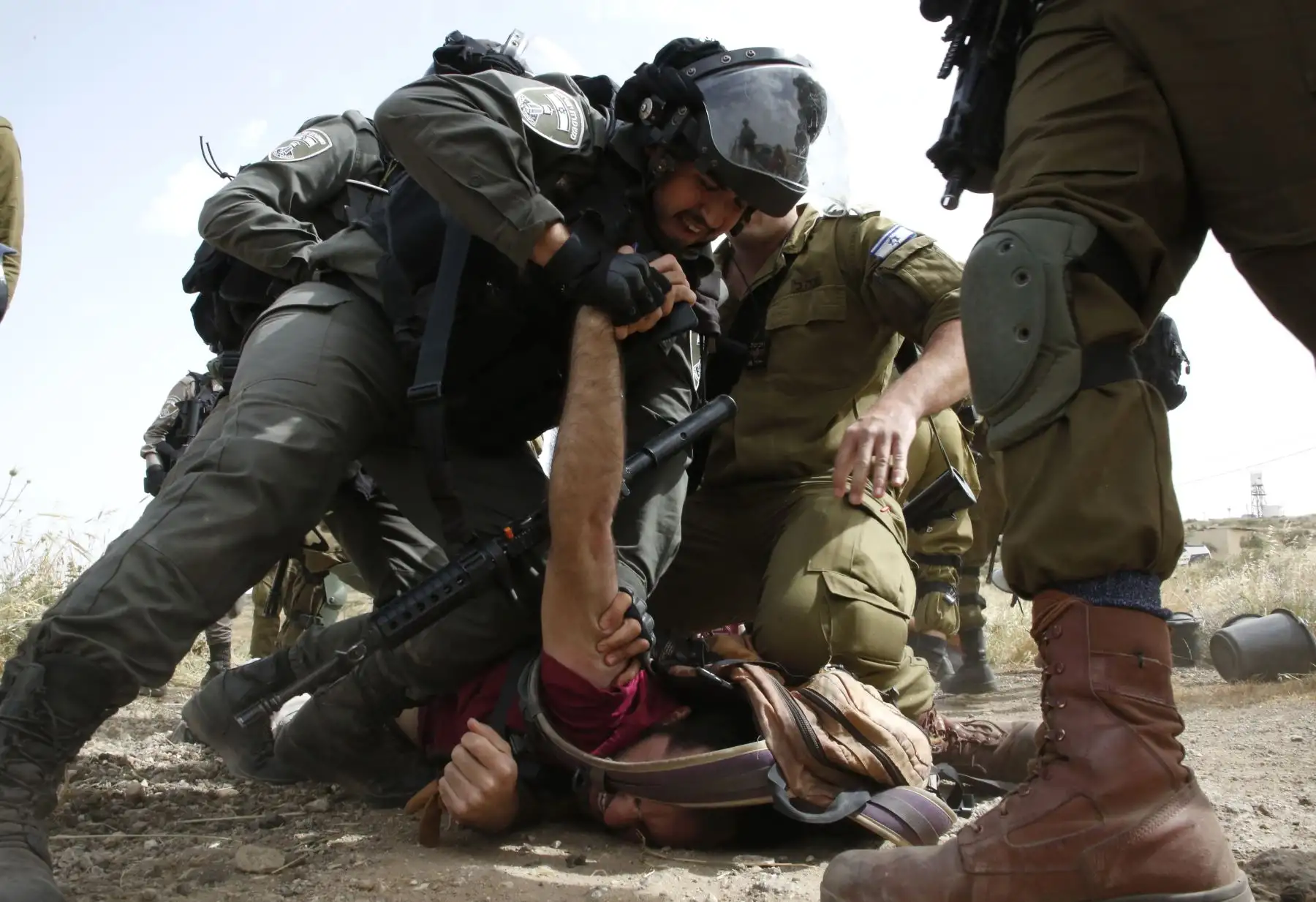 Fuerzas israelíes inmovilizan a activistas mientras que militantes extranjeros, israelíes y palestinos intentan despejar un camino que conduce a las aldeas palestinas, cerca de la ciudad de Yatta en la Cisjordania. Foto: AFP