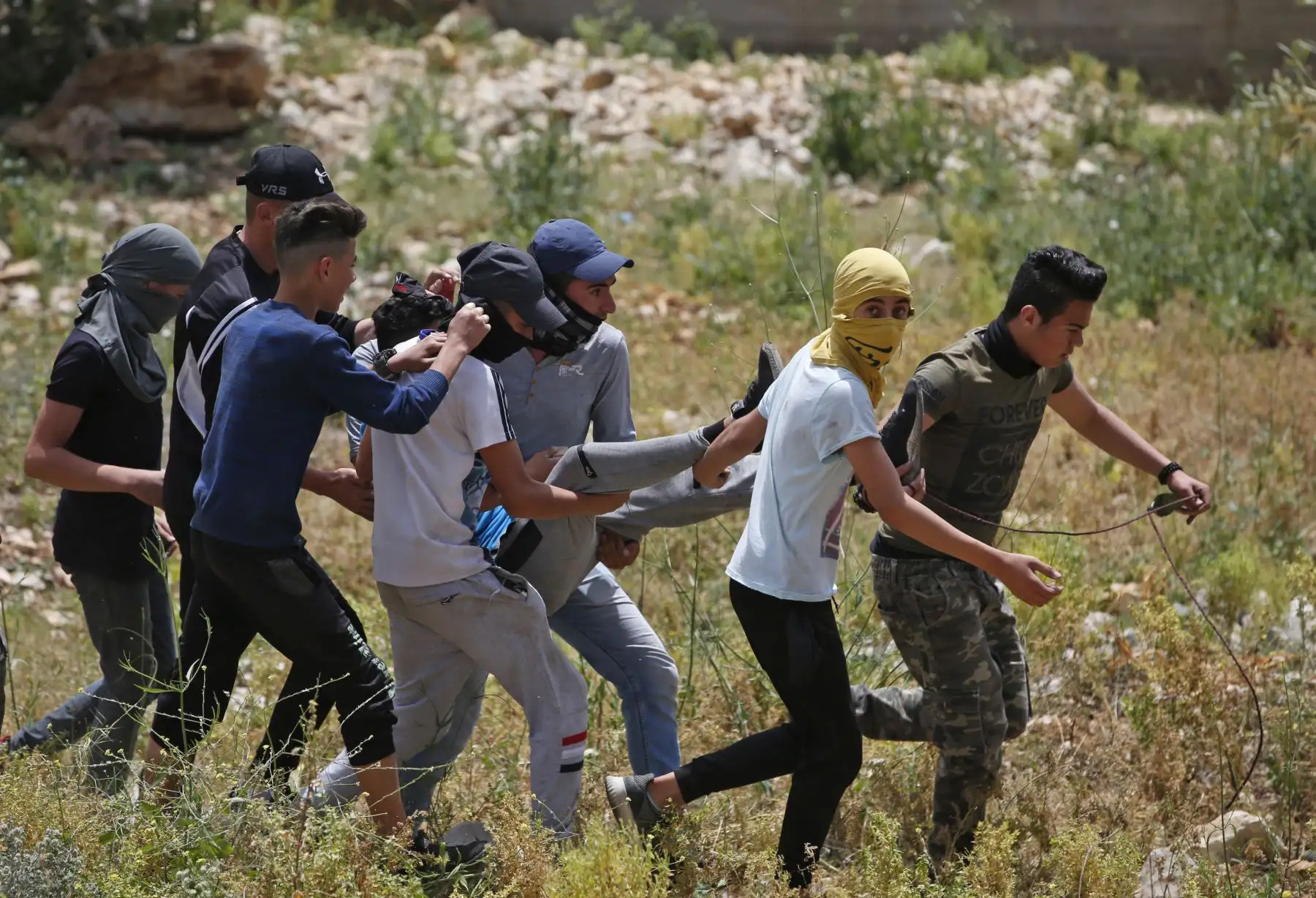 Palestinos llevan a un manifestante herido durante los enfrentamientos con las fuerzas israelíes. Foto: AFP