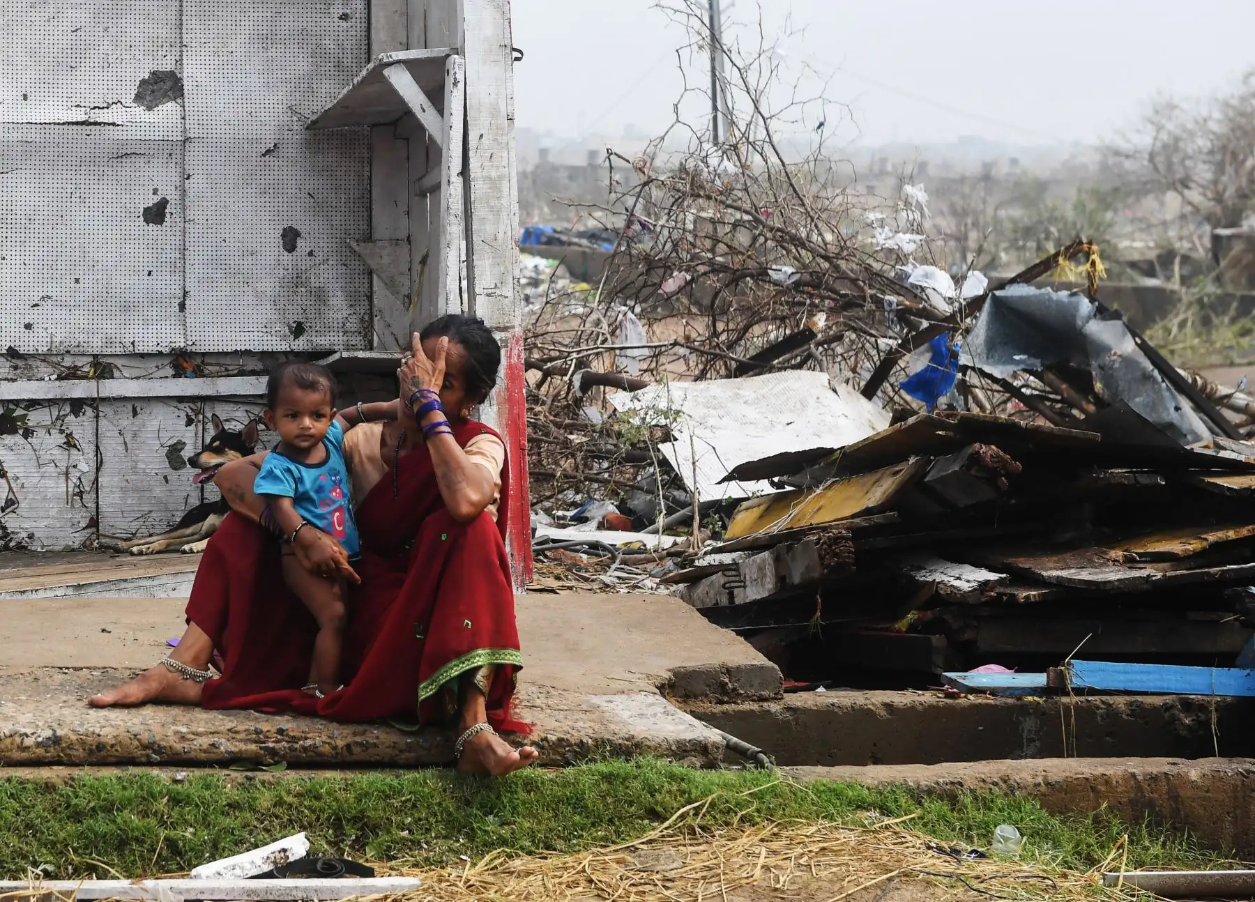 Una mujer india se sienta con su hijo junto a los edificios dañados por la tormenta en Puri, en el estado indio oriental de Odisha, después de que el ciclón Fani barriera la zona. 
Foto: ANDINA/AFP