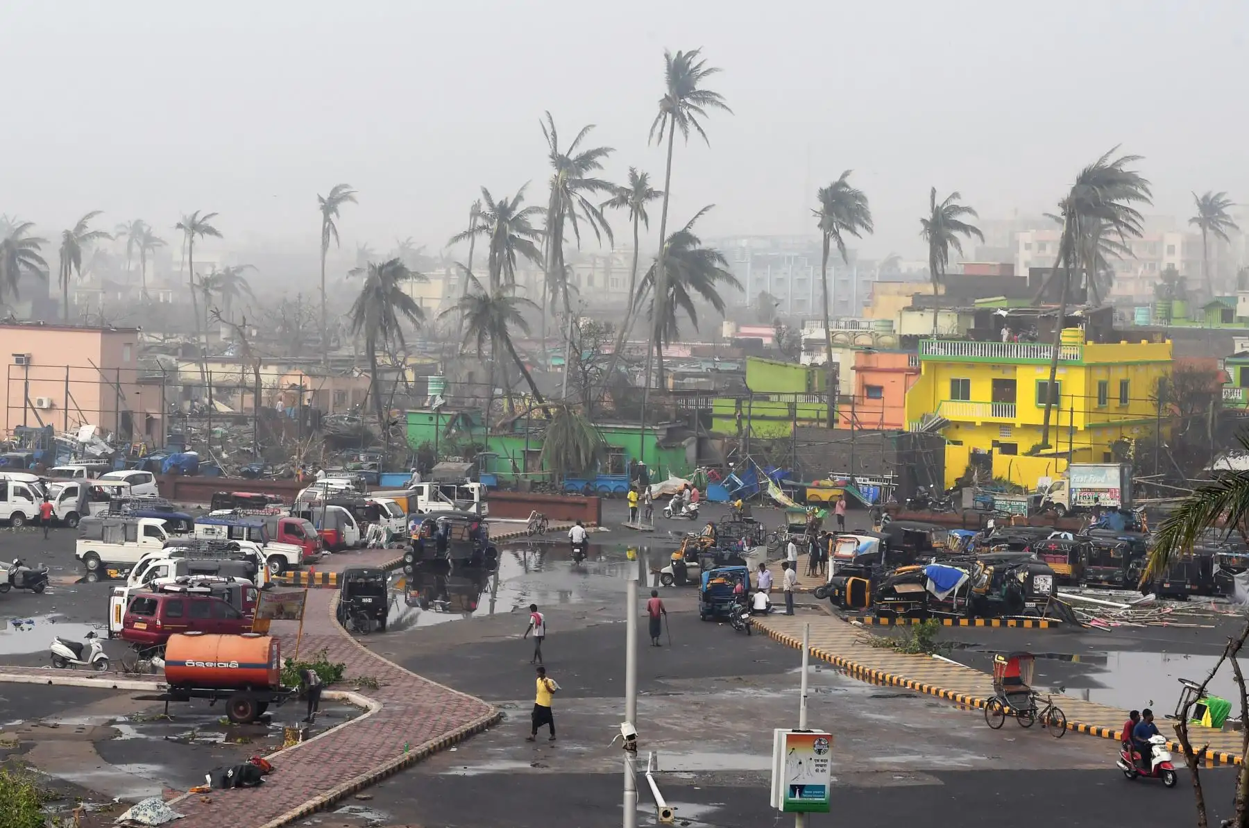 La gente se reúne junto a los edificios dañados por la tormenta y las palmeras en Puri, en el estado indio oriental de Odisha, después de que el ciclón Fani barriera el área. 
Foto:AFP