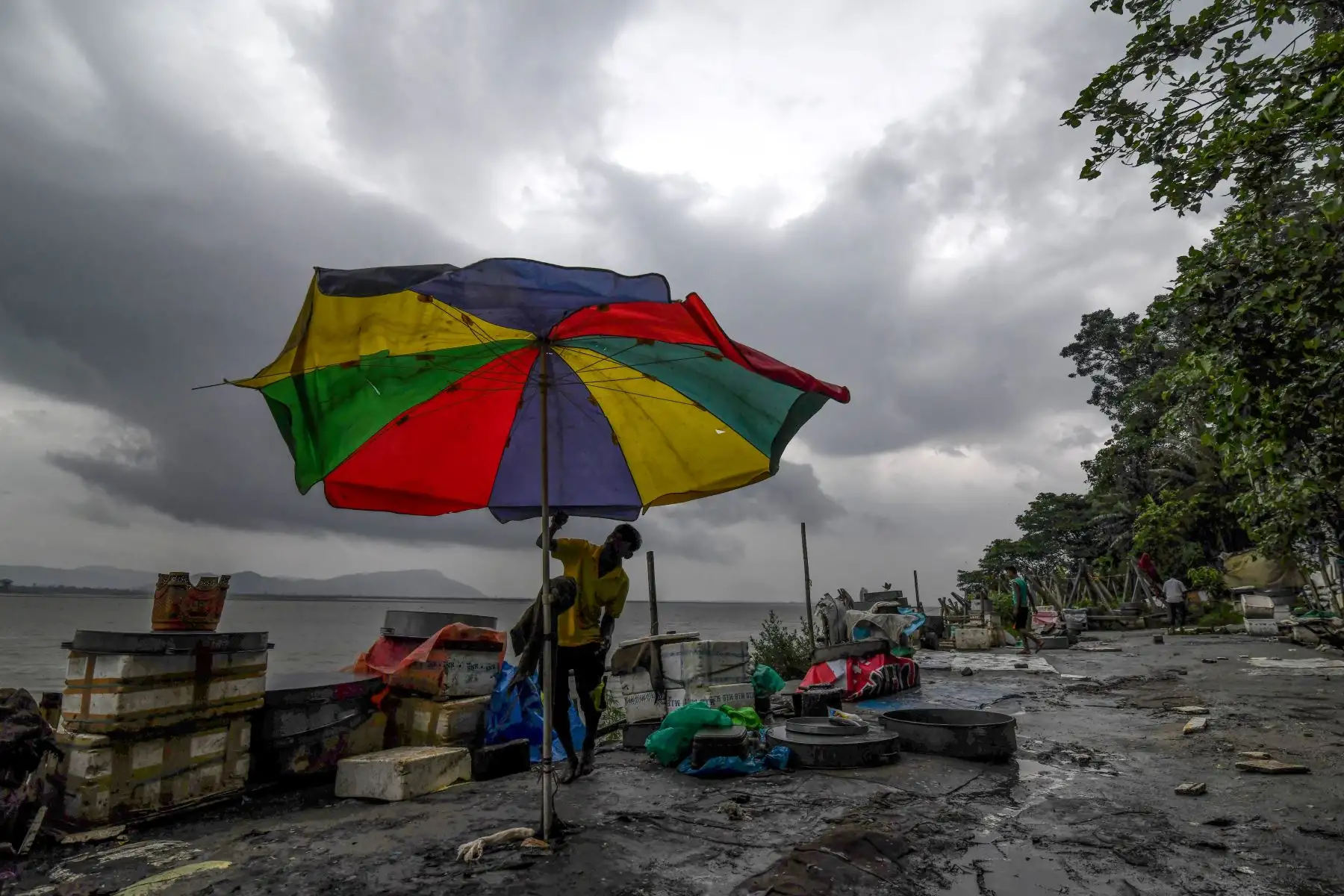 Un vendedor de pescado indio intenta cerrar una sombrilla cuando el viento fuerte sopla en un mercado de pescado en la orilla del río Brahmaputra en Guwahati.
 El ciclón Fani, uno de los más grandes que ha golpeado a la India en años, llegó a Bangladesh, después de dejar un rastro de destrucción mortal en la India.
Foto: AFP