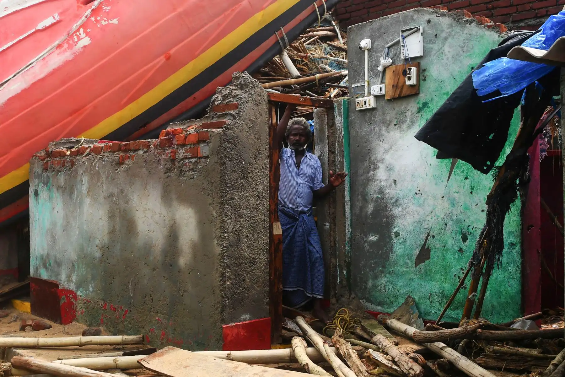 Un hombre indio mira desde un edificio dañado, con un barco de pesca alojado en el techo, a lo largo del paseo marítimo de Puri, en el estado indio oriental de Odisha, después de que el ciclón Fani barriera el área. 
Foto:AFP