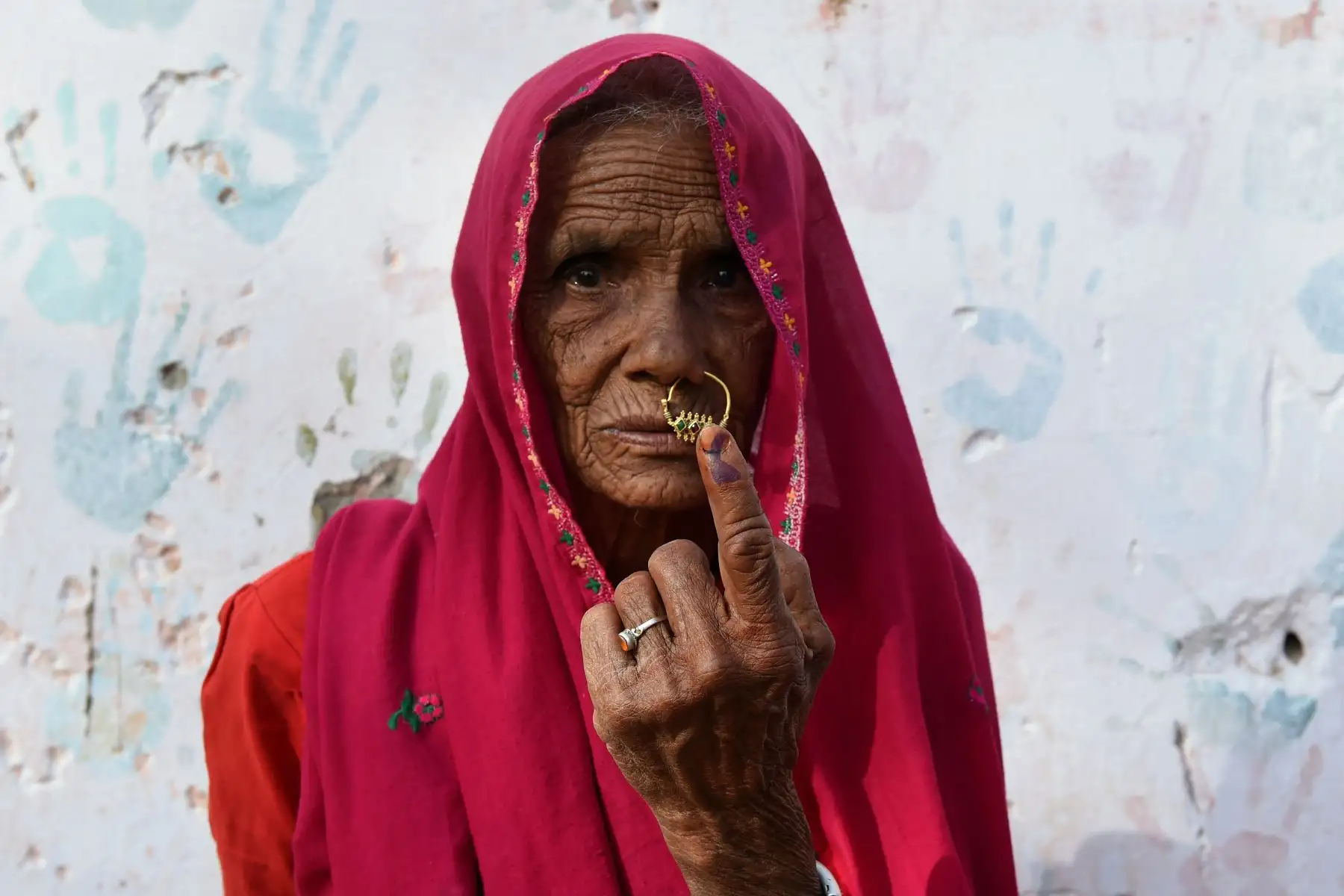Una mujer de la India posa para una foto mientras muestra su dedo marcado con tinta después de emitir su voto durante las elecciones generales de la India. Foto: AFP