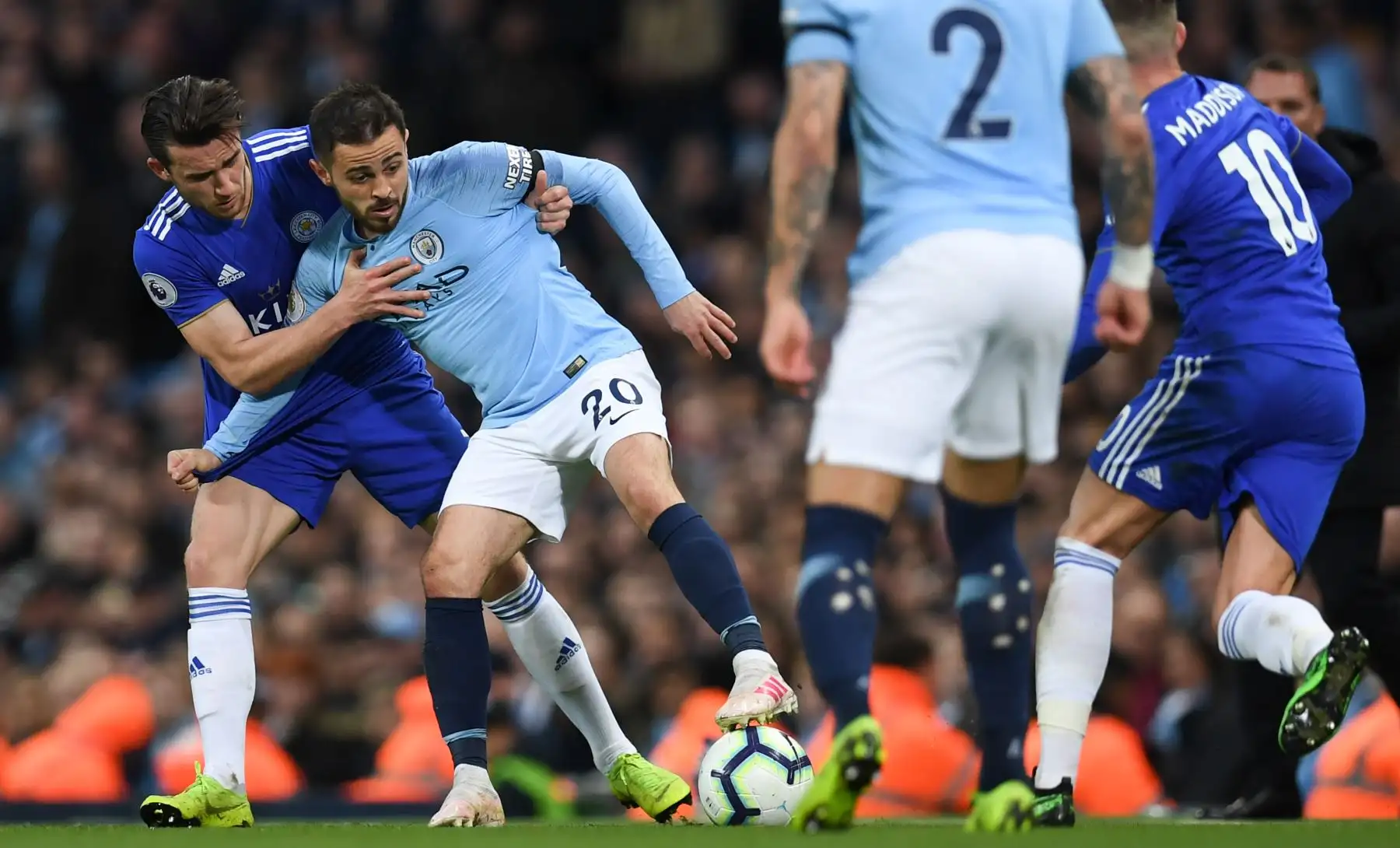 El defensa inglés de Leicester City, Ben Chilwell, presiona al mediocampista portugués del Manchester City Bernardo Silva . Foto: AFP