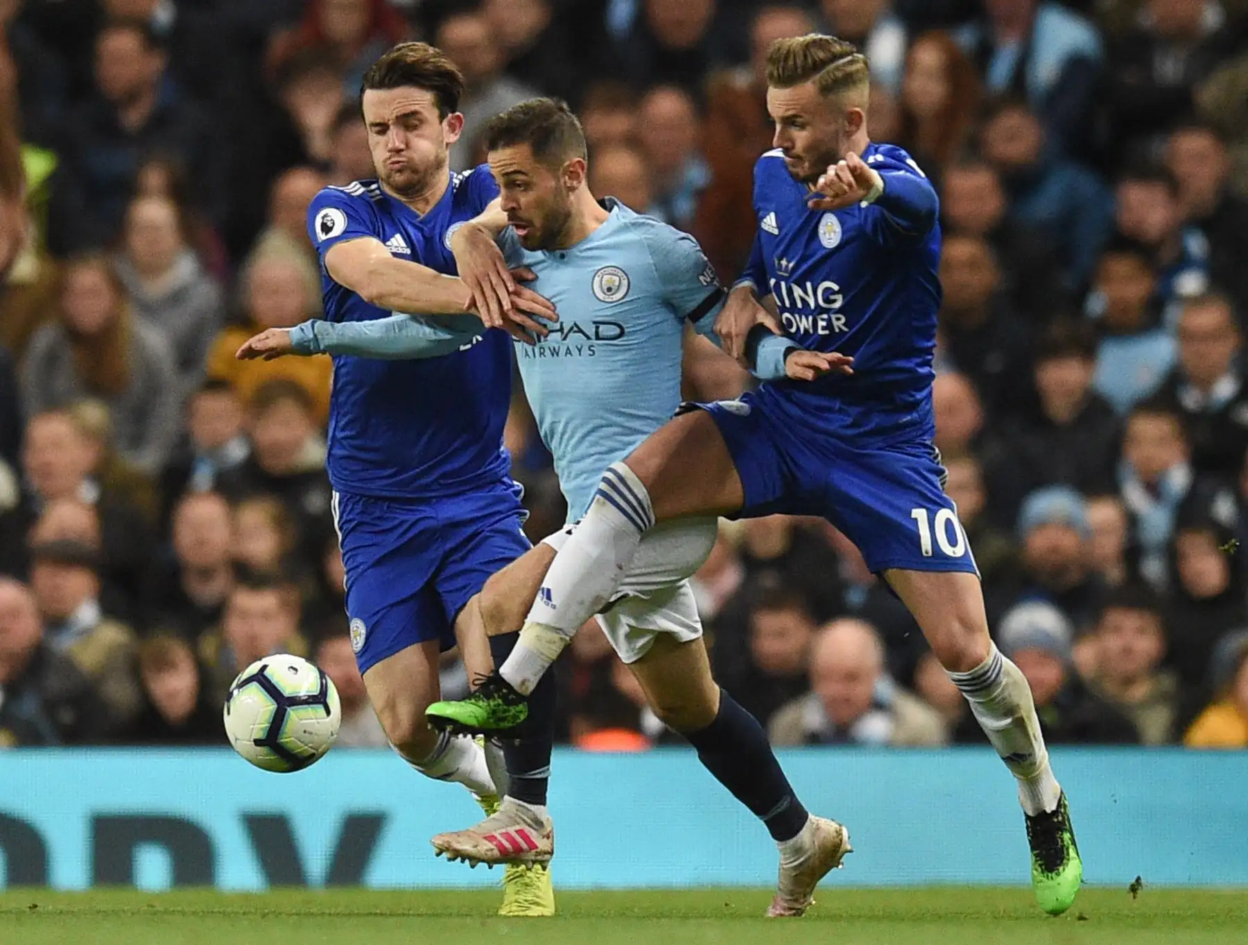 El defensa inglés de Leicester City Ben Chilwell  y el mediocampista inglés de Leicester City James Maddison desafían al mediocampista portugués del Manchester City Bernardo Silva. Foto: AFP