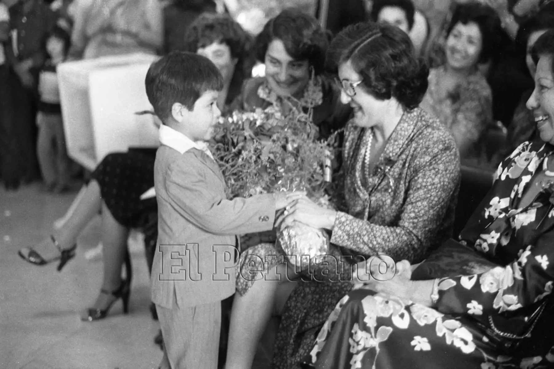 Lima - 8 mayo 1981 / Celebración por el Día de la Madre en el Ministerio de Salud, niño pequeño entrega un ramo de flores a una de las madres trabajadoras de la institución. 
Foto: Archivo diario El Peruano