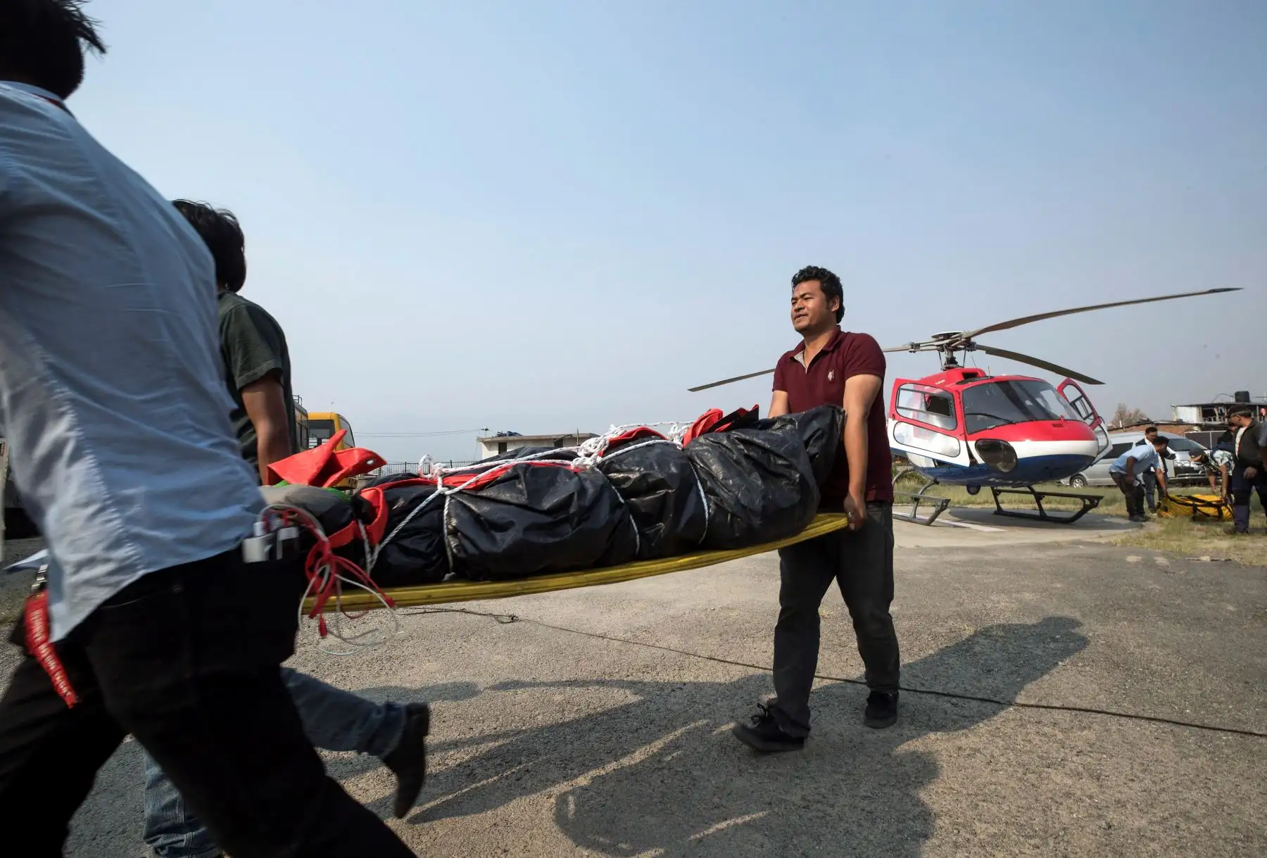 Varios hombres transportan el cuerpo de Richard Hidalgo, desde el helicóptero hasta un hospital de Katmandú (Nepal). Foto: EFE