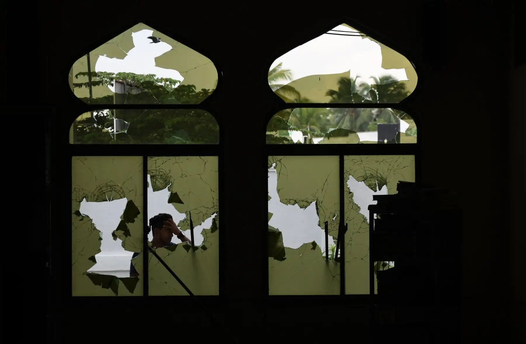Un hombre camina por una tienda dañada después de un atentado en Sri Lanka. Foto: AFP