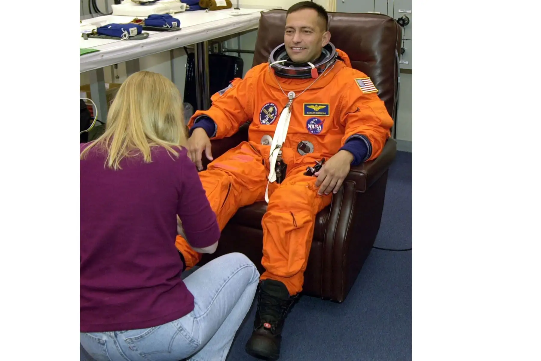 Carlos Noriega, especialista en misiones del transbordador espacial estadounidense, recibe ayuda con sus botas, el 28 de noviembre de 2000, en el Centro Espacial Kennedy, Florida.Foto: AFP
