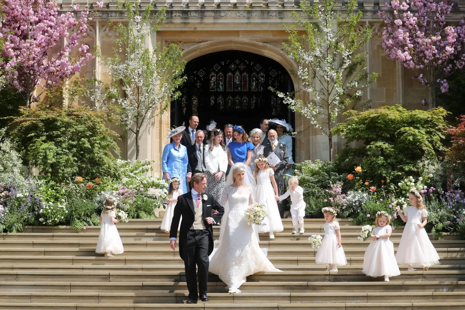 Los recién casados Thomas Kingston (CL) y Lady Gabriella Windsor (CR) caminan por los escalones con sus damas de honor, los muchachos de la página y los invitados después de su ceremonia de boda, en la Capilla de San Jorge en el Castillo de Windsor, Windsor, al oeste de Londres.
Lady Gabriella es la hija del príncipe y la princesa Michael de Kent. El príncipe Michael, es el primo de la reina Isabel II.
Foto:AFP