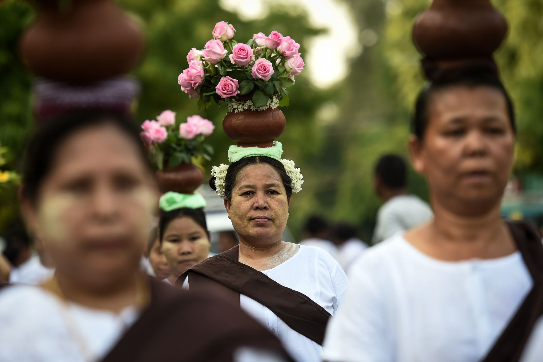 Los devotos budistas llevan agua y flores durante el cumpleaños de Buda en Mandalay.
 Los budistas conmemoran el nacimiento de Buda, alcanzando la iluminación y la muerte el día de la luna llena.
Foto:AFP