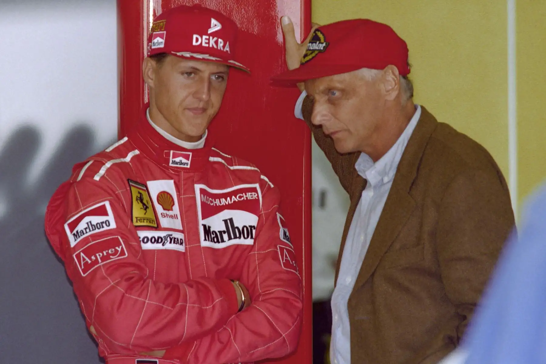 El piloto alemán Michael Schumacher habla con el ex piloto austriaco Niki Lauda durante el Gran Premio de Fórmula Uno de Australia el 7 de marzo de 1996 en Melbourne. Foto: AFP