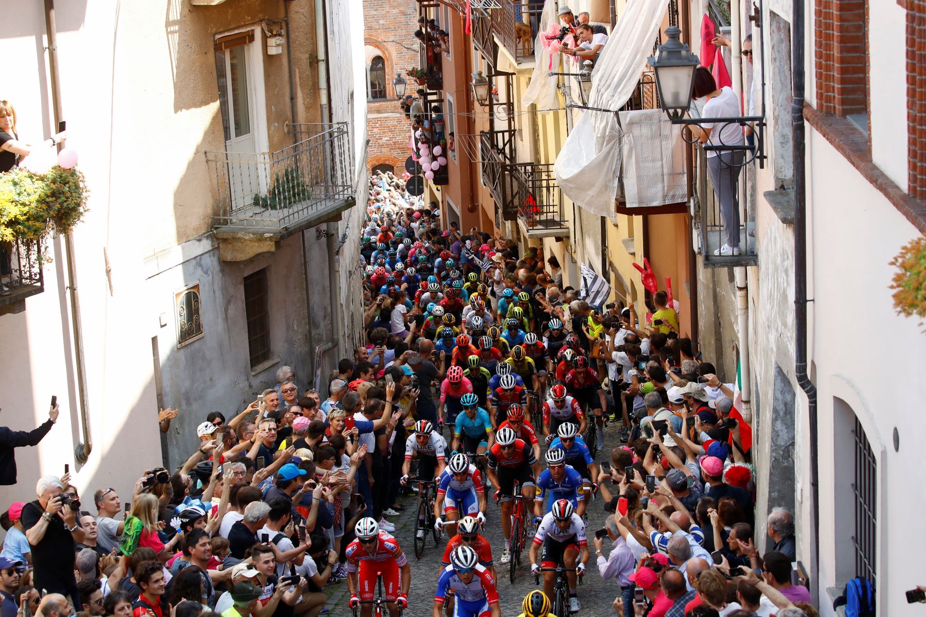Ciclistas suben la muralla de San Mauricio en la ciudad de Pinerolo durante la etapa doce del 102º Giro de Italia de 158 km desde Cuneo hasta Pinerolo. Foto: AFP