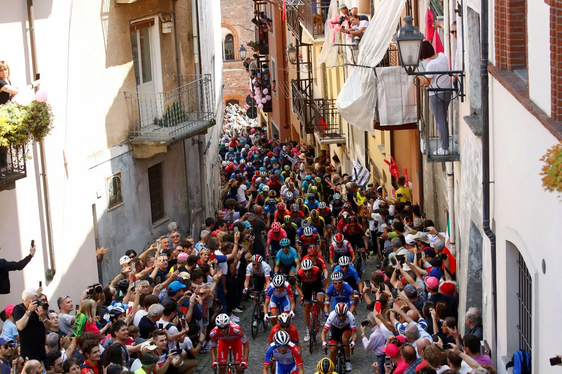 Ciclistas suben la muralla de San Mauricio en la ciudad de Pinerolo durante la etapa doce del 102º Giro de Italia de 158 km desde Cuneo hasta Pinerolo. Foto: AFP