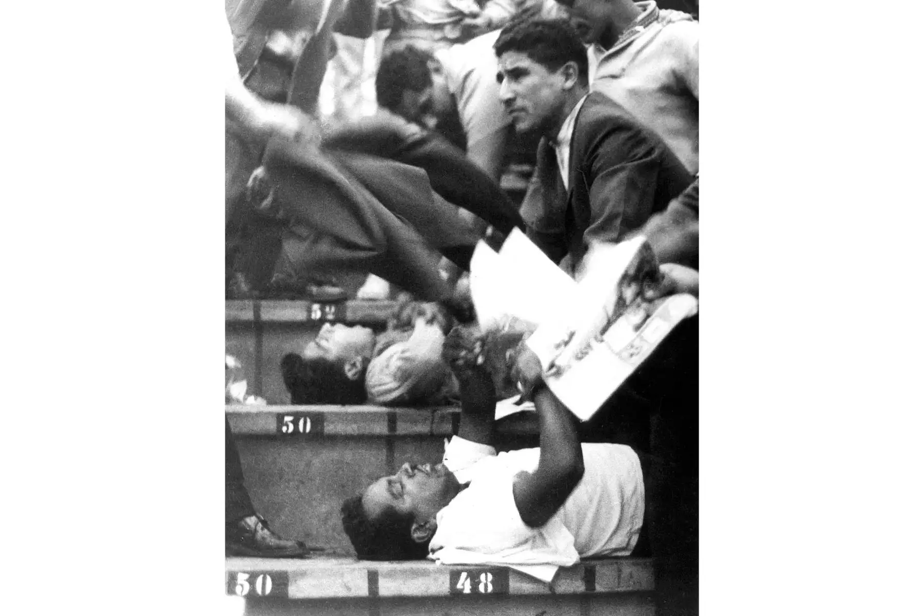 Imagen distribuida por el Instituto Peruano de Deportes (IPD) que muestra a personas que asisten a otros en los stands del Estadio Nacional de Lima el 24 de mayo de 1964, durante desórdenes después de un partido de clasificación para los Juegos Olímpicos de Tokio entre Perú y Argentina, que causó la muerte De los 320 aficionados al fútbol. La indignación masiva después de que se cancelara un gol peruano causó que la policía lanzara gas lacrimógeno al público generando un caos y una estampida en la que perso