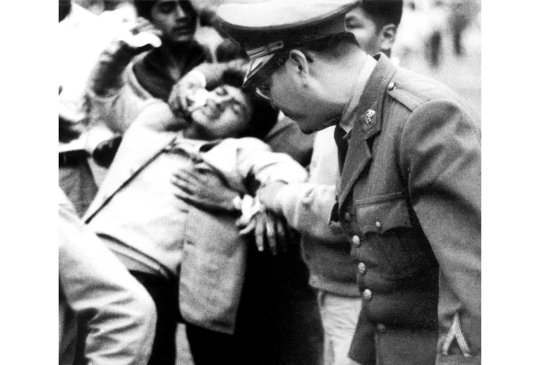 Foto distribuida por el Instituto Peruano de Deportes (IPD) que muestra a hombres que llevaban a una persona herida en el Estadio Nacional de Lima el 24 de mayo de 1964, durante desórdenes después de un partido de clasificación para los Juegos Olímpicos de Tokio entre Perú y Argentina, que causó la muerte de 320 aficionados al fútbol. La indignación masiva después de que se cancelara un gol peruano causó que la policía lanzara gas lacrimógeno al público generando un caos y una estampida en la que personas m