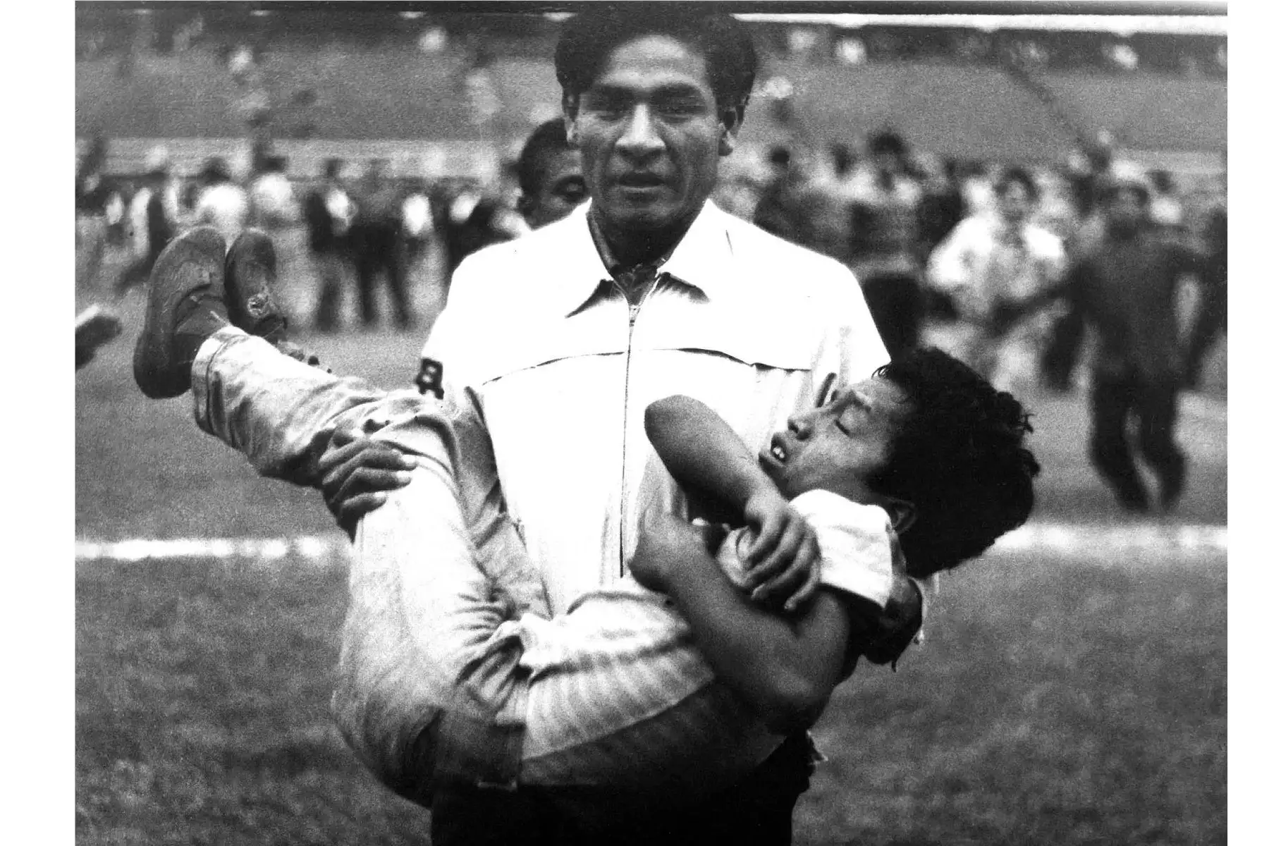Foto distribuida por el Instituto Peruano de Deportes (IPD) que muestra a hombres que llevaban a una persona herida en el Estadio Nacional de Lima el 24 de mayo de 1964, durante desórdenes después de un partido de clasificación para los Juegos Olímpicos de Tokio entre Perú y Argentina, que causó la muerte de 320 aficionados al fútbol. La indignación masiva después de que se cancelara un gol peruano causó que la policía lanzara gas lacrimógeno al público generando un caos y una estampida en la que personas m