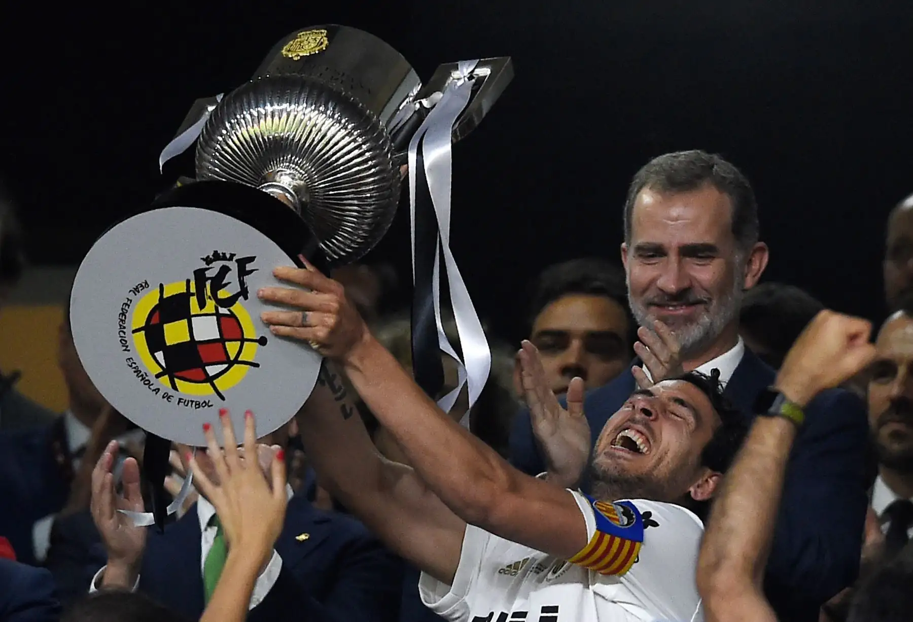 El mediocampista español Daniel Parejo, tiene el trofeo frente al Rey Felipe VI de España, que celebra después de ganar el último partido de fútbol de la Copa del Rey de España contra el Barcelona en el estadio Benito Villamarin de Sevilla.Foto:AFP