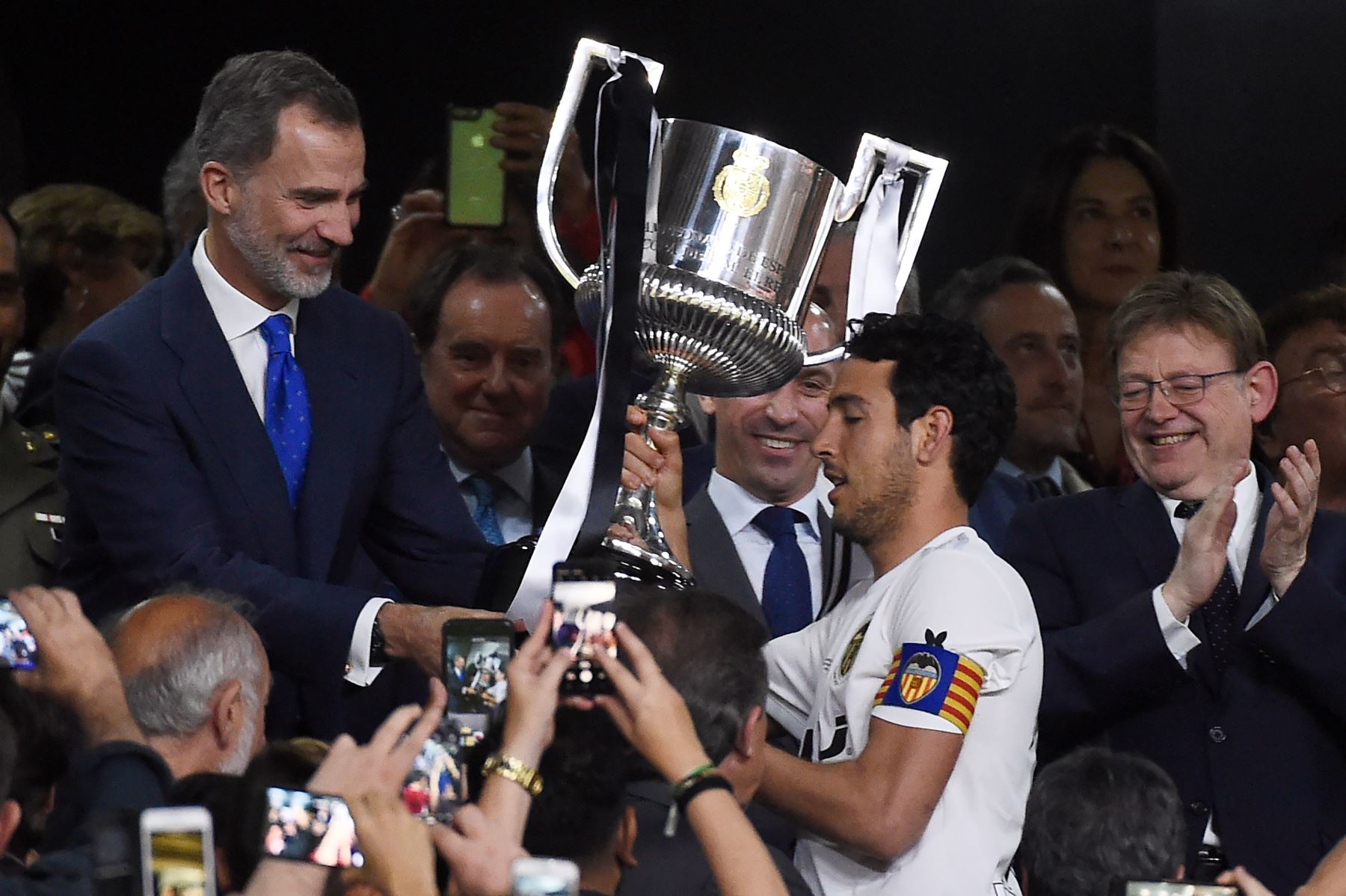 El rey español Felipe VI le entrega el trofeo al mediocampista, Daniel Parejo, luego de ganar el último partido de fútbol de la Copa del Rey de España entre Barcelona y Valencia,en el estadio Benito Villamarin de Sevilla.Foto:AFP