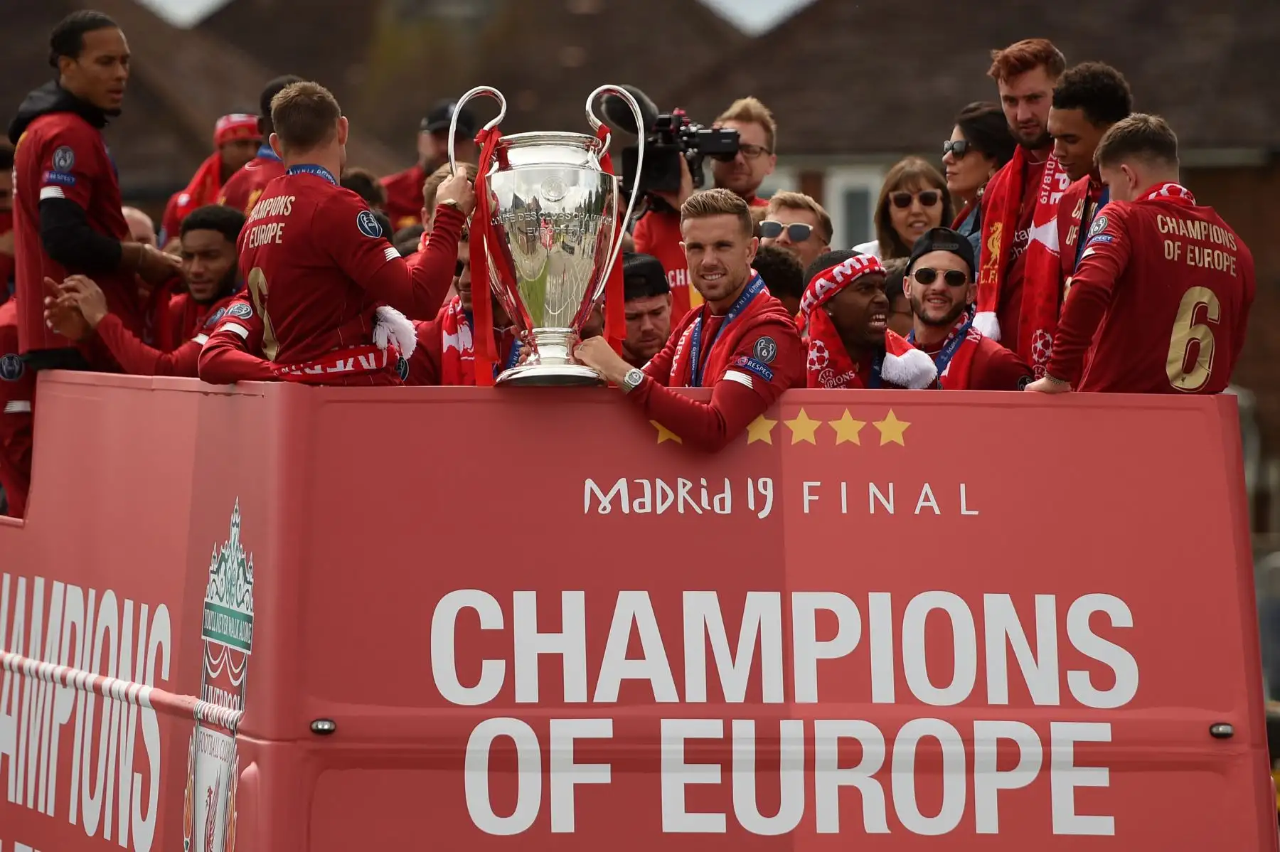 El mediocampista inglés del Liverpool, Jordan Henderson (C), se lleva el trofeo de la Copa de Europa de Campeones durante un desfile de autobuses en Liverpool, el noroeste de Inglaterra, después de ganar el último partido de fútbol de la UEFA Champions League entre el Liverpool y el Tottenham. 
Foto:AFP