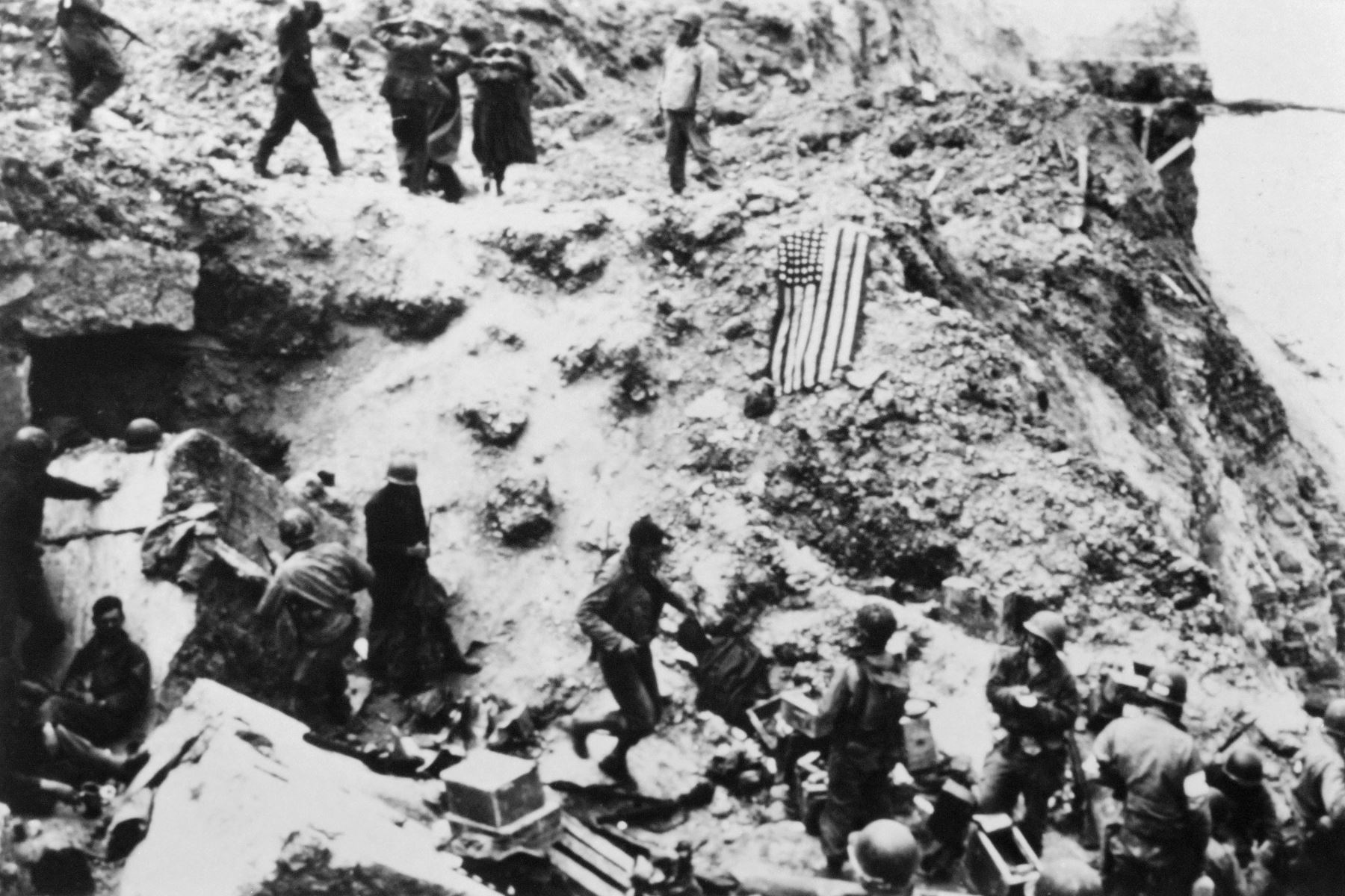 Los soldados estadounidenses del 2º batallón de guardabosques rodean a prisioneros alemanes el 6 de junio de 1944 en la Pointe du Hoc ubicada en un acantilado que domina la playa de Omaha después de que las fuerzas aliadas asaltaron las playas de Normandía durante el Día D. Elementos del 2º Batallón de Guardabosques escalaron el acantilado de 100 pies y se apoderaron de las piezas de artillería alemana que podrían haber disparado contra las fuerzas aliadas que desembarcaron en la playa de Omaha. El día D, 6