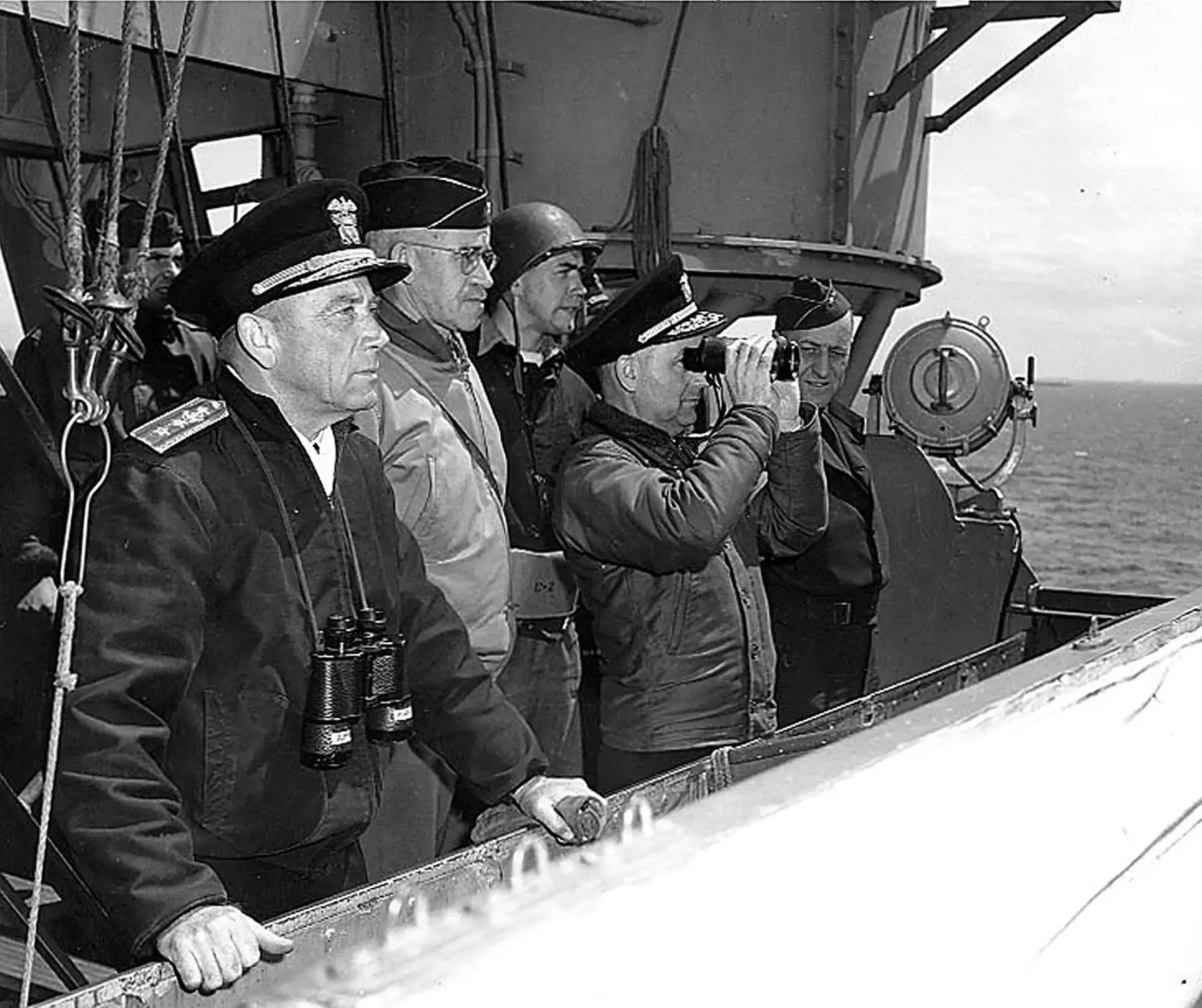 Esta imagen de la Marina de los EE. UU. Del 8 de junio de 1944 muestra a los oficiales superiores de EE. UU. Observando las operaciones desde el puente del USS Augusta (CA-31), frente a Normandía, Francia. Aquí, desde la izquierda, se encuentran: el contraalmirante Alan G. Kirk, USN, Comandante de la Fuerza de Tarea de la Armada Occidental; LTG. Omar N. Bradley, Ejército de los Estados Unidos, Comandante General, Primer Ejército de los Estados Unidos; Contraalmirante Arthur D. Struble, USN, (con binoculares
