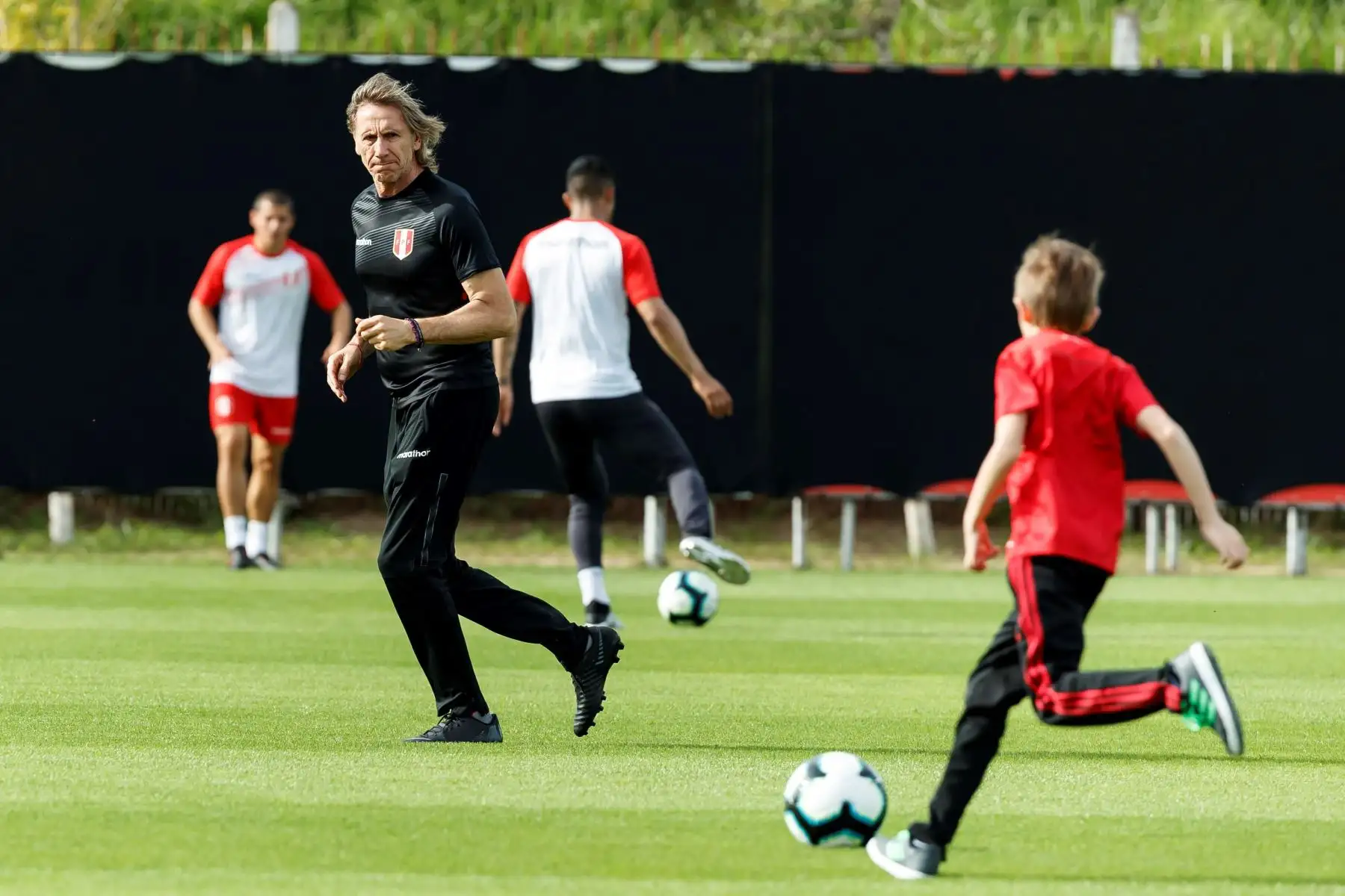 El entrenador de la selección peruana de fútbol,Ricardo Gareca, participa junto a su nieto Benjamín en un entrenamiento del equipo en Porto Alegre, Brasil. Foto: EFE