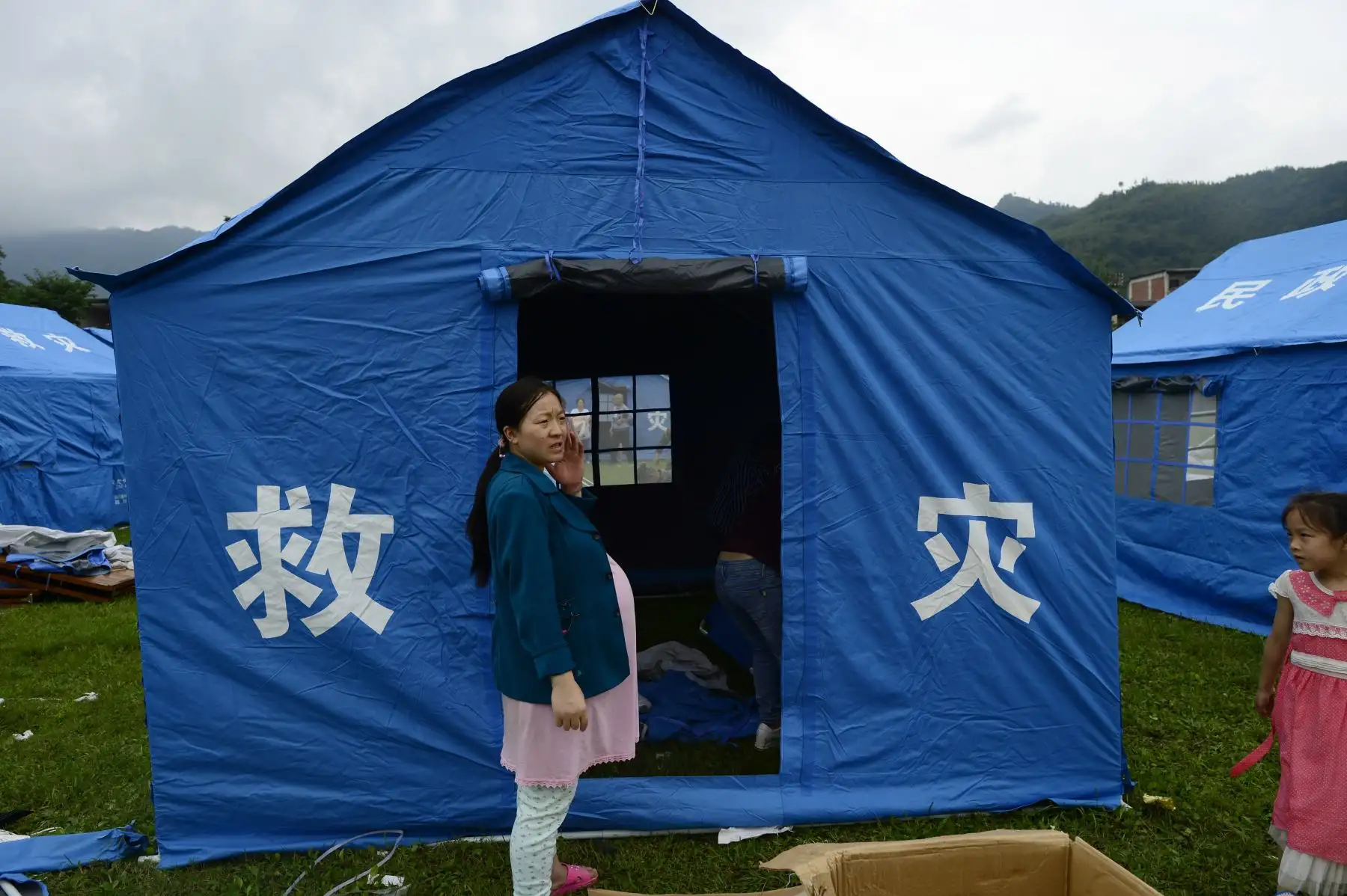 Una mujer embarazada está parada frente a una tienda de campaña en un campamento temporal establecido para sobrevivientes del terremoto en Yibin. Foto: AFP