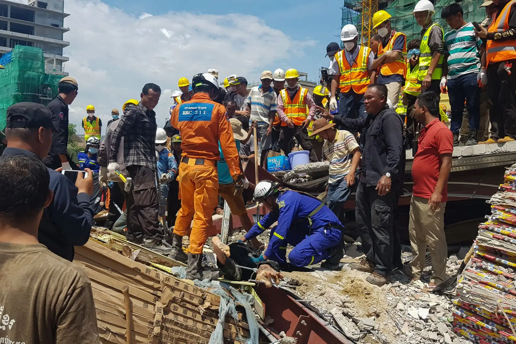 Los trabajadores de rescate llevan el cuerpo de una víctima que sacaron de los escombros un día después de que un edificio en construcción colapsara en Sihanoukville. Los trabajadores de rescate recogieron entre los escombros a 17 personas fallecidas de un edificio colapsado de propiedad china . 
Foto: AFP