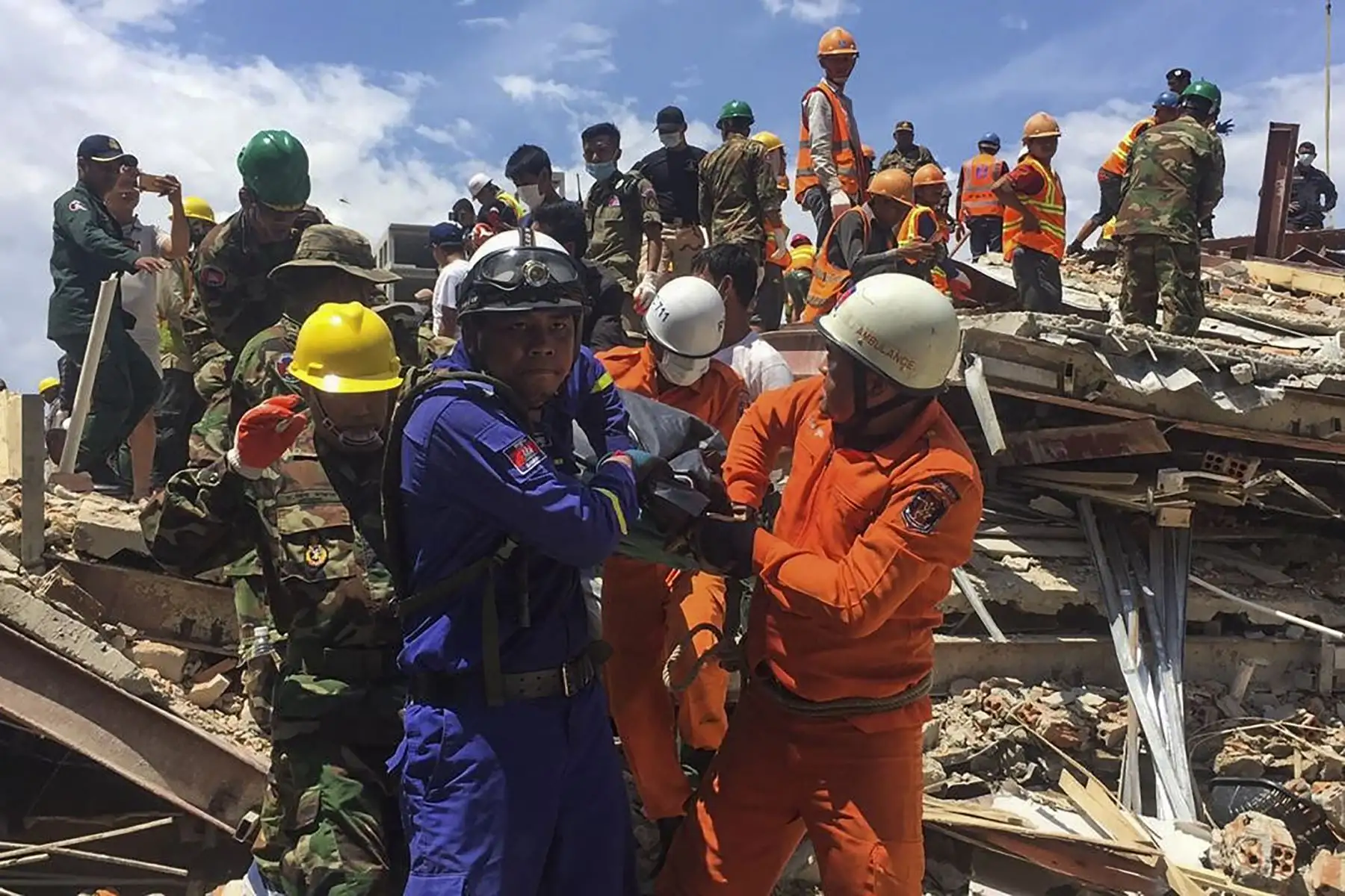 Los trabajadores de rescate llevan el cuerpo de una víctima que sacaron de los escombros un día después de que un edificio en construcción colapsara en Sihanoukville. Los trabajadores de rescate recogieron entre los escombros a 17 personas fallecidas de un edificio colapsado de propiedad china . 
Foto: AFP