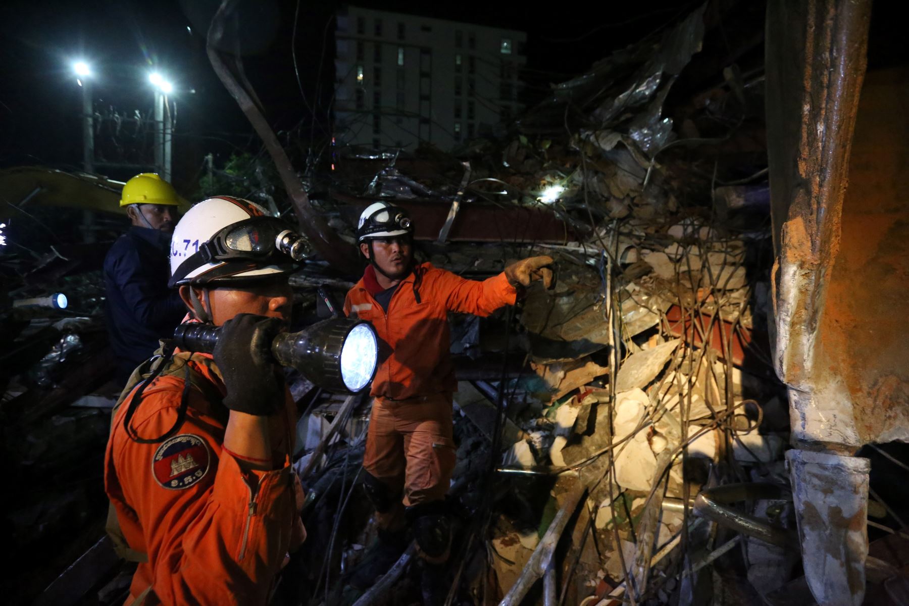 Los trabajadores de rescate llevan el cuerpo de una víctima que sacaron de los escombros un día después de que un edificio en construcción colapsara en Sihanoukville. Los trabajadores de rescate recogieron entre los escombros a 17 personas fallecidas de un edificio colapsado de propiedad china . 
Foto: AFP