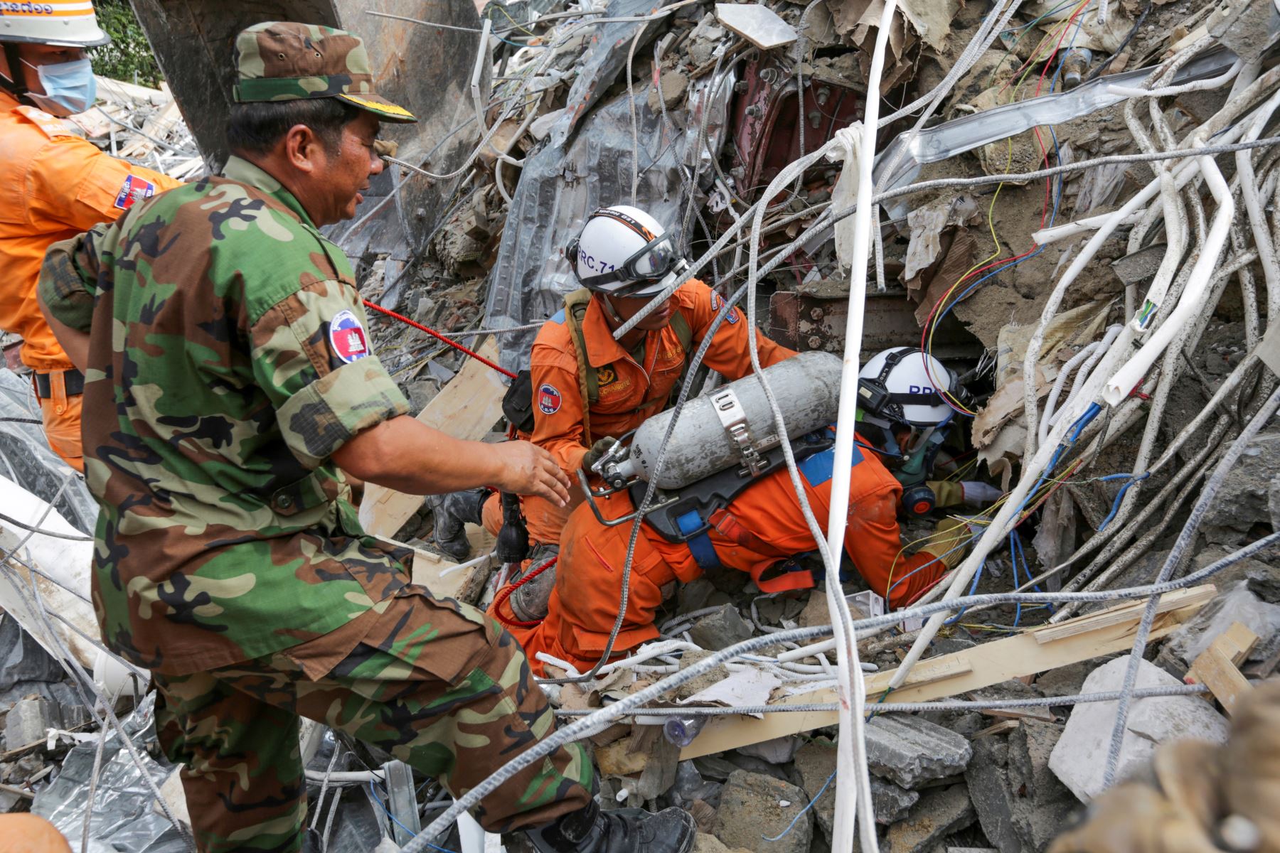 Los trabajadores de rescate llevan el cuerpo de una víctima que sacaron de los escombros un día después de que un edificio en construcción colapsara en Sihanoukville. Los trabajadores de rescate recogieron entre los escombros a 17 personas fallecidas de un edificio colapsado de propiedad china . 
Foto: AFP
