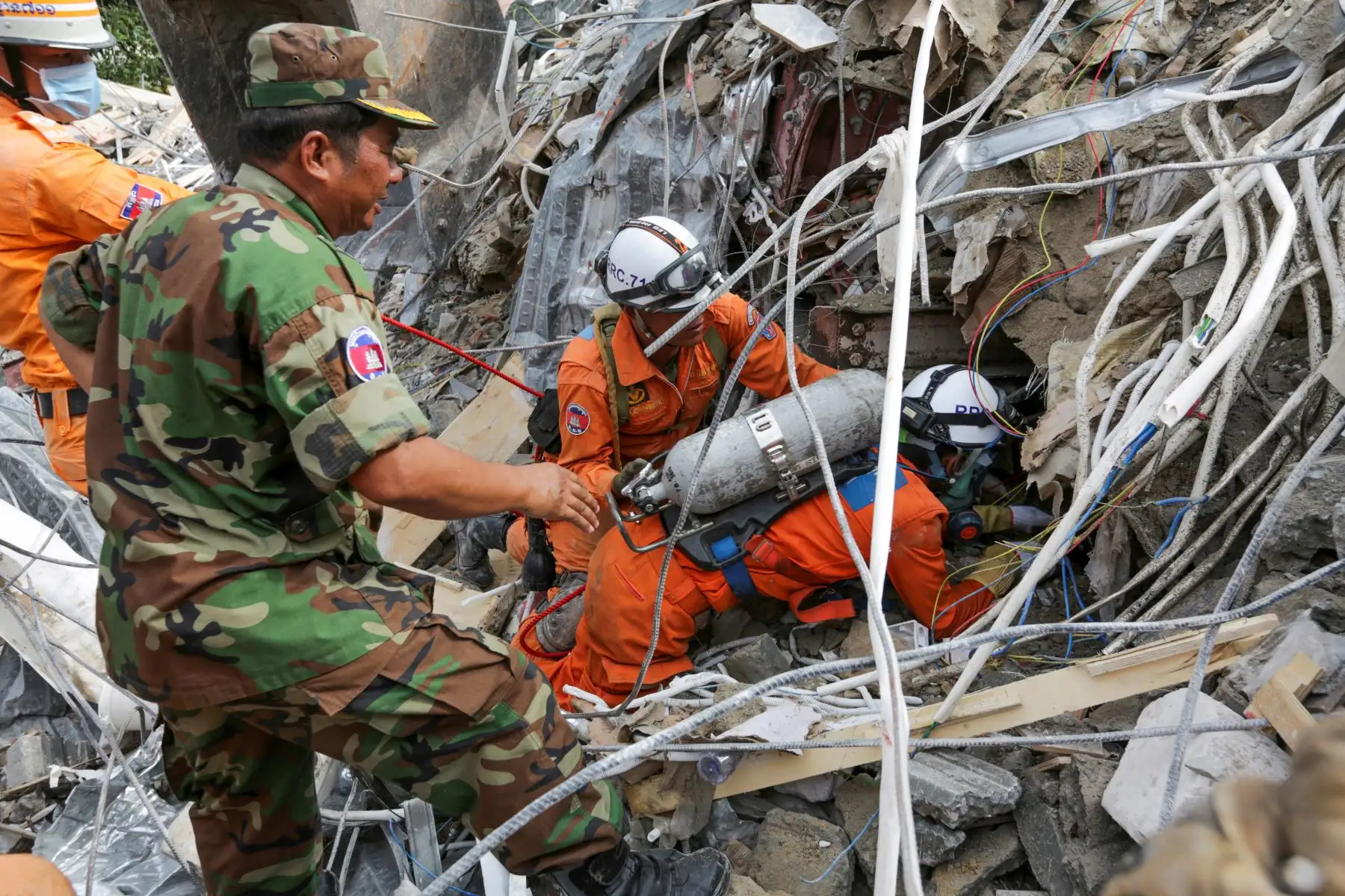 Los trabajadores de rescate llevan el cuerpo de una víctima que sacaron de los escombros un día después de que un edificio en construcción colapsara en Sihanoukville. Los trabajadores de rescate recogieron entre los escombros a 17 personas fallecidas de un edificio colapsado de propiedad china . 
Foto: AFP