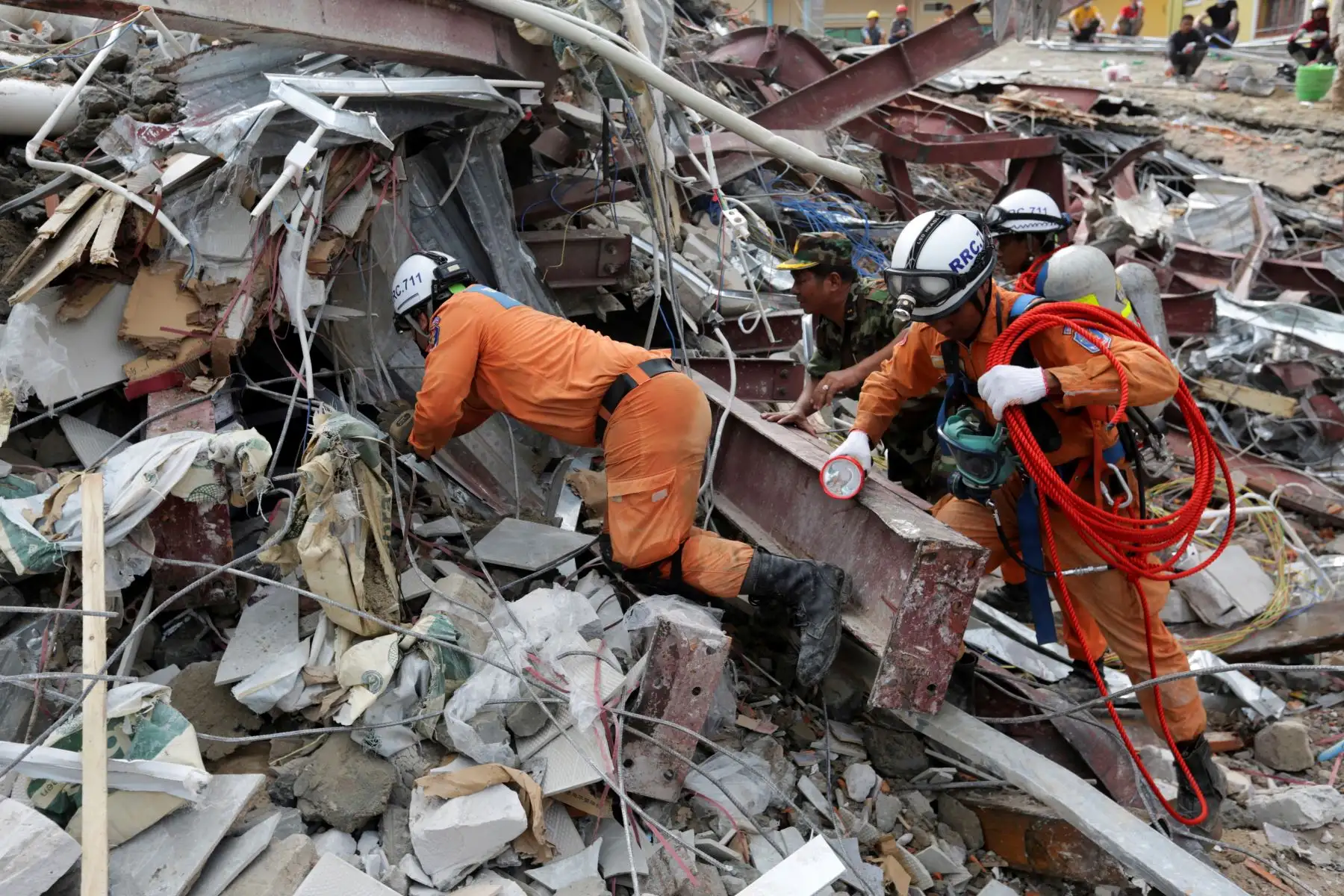 Los trabajadores de rescate llevan el cuerpo de una víctima que sacaron de los escombros un día después de que un edificio en construcción colapsara en Sihanoukville. Los trabajadores de rescate recogieron entre los escombros a 17 personas fallecidas de un edificio colapsado de propiedad china . 
Foto: AFP